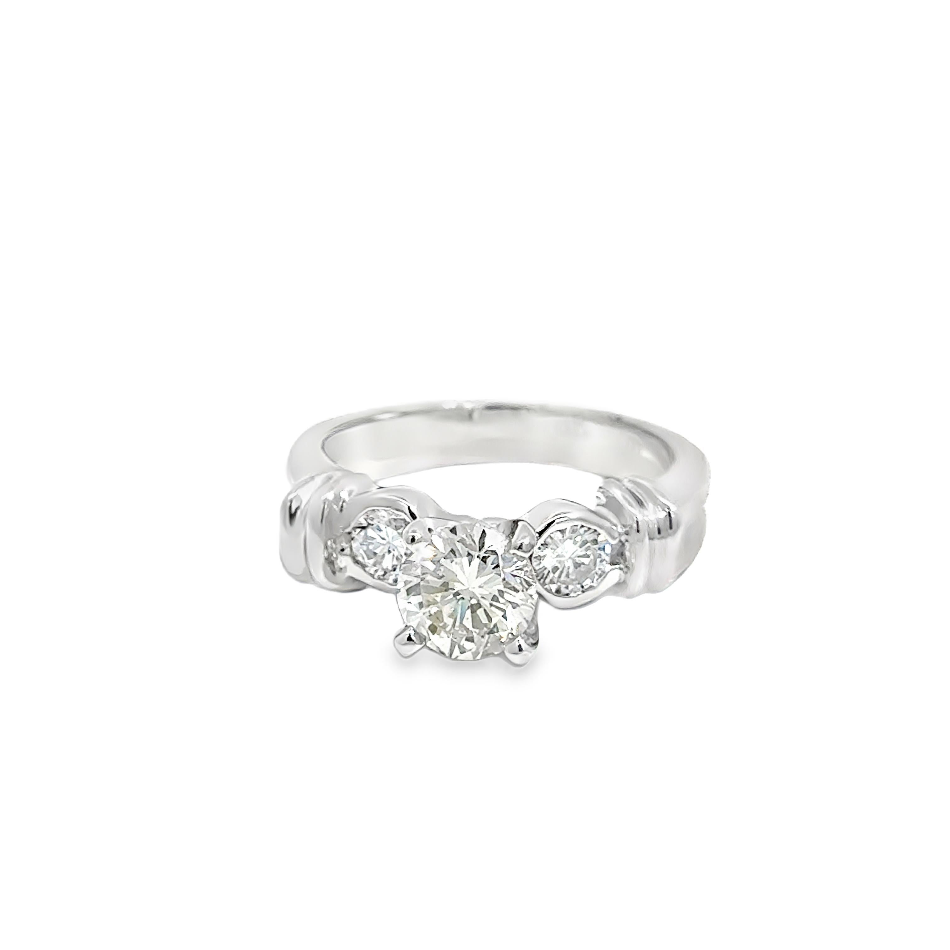 An elegant 18k white gold ring featuring a 1.00ct round brilliant center diamond, flanked by two round side diamonds totaling 0.40ct. The ring’s classic three-stone design symbolizes past, present, and future, with a total weight of 6.50 grams,