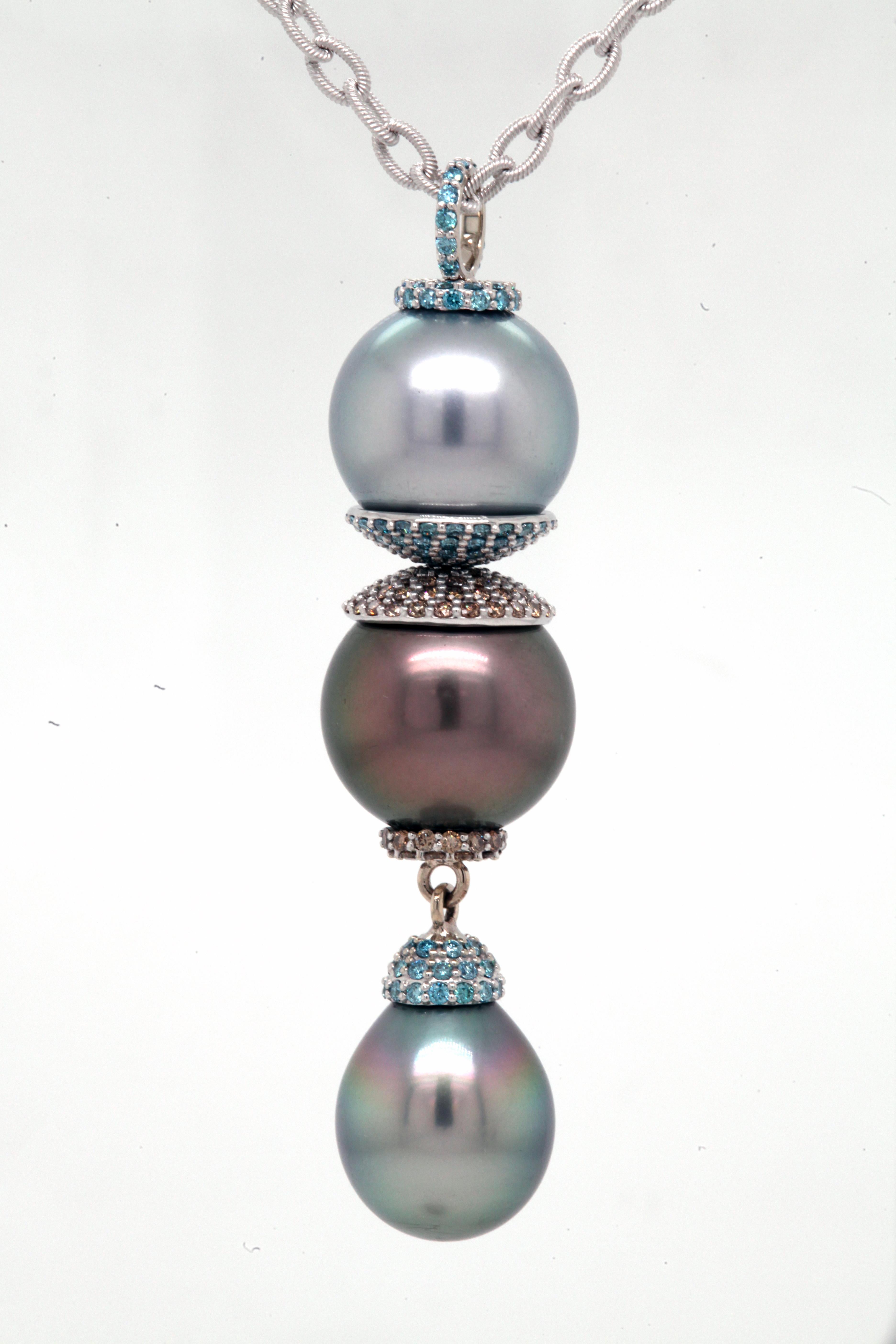 An 18k white gold triple drop pearl pendant set with Tahitian pearls, one light grey/blue,14.07mm, one dark grey/brown,14.44mm, and one bluish green teardrop shape, 12.5mm x 15.5mm. Also set with 1.088 carats of 1.2mm aqua blue diamonds, and .704