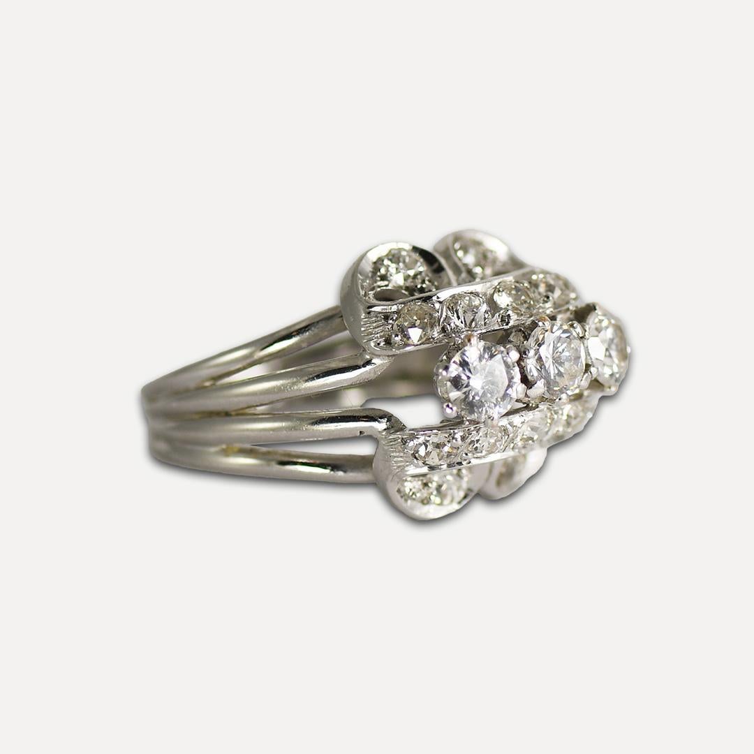 Ladies' vintage diamond and cubic zirconia ring with 18k white gold setting.
Tests 18k and weighs 8.4 grams.
The three center diamonds are cubic zirconia.
The side diamonds are old cuts, .63 total carats, i to j color, Vs to Si.
Two of the small