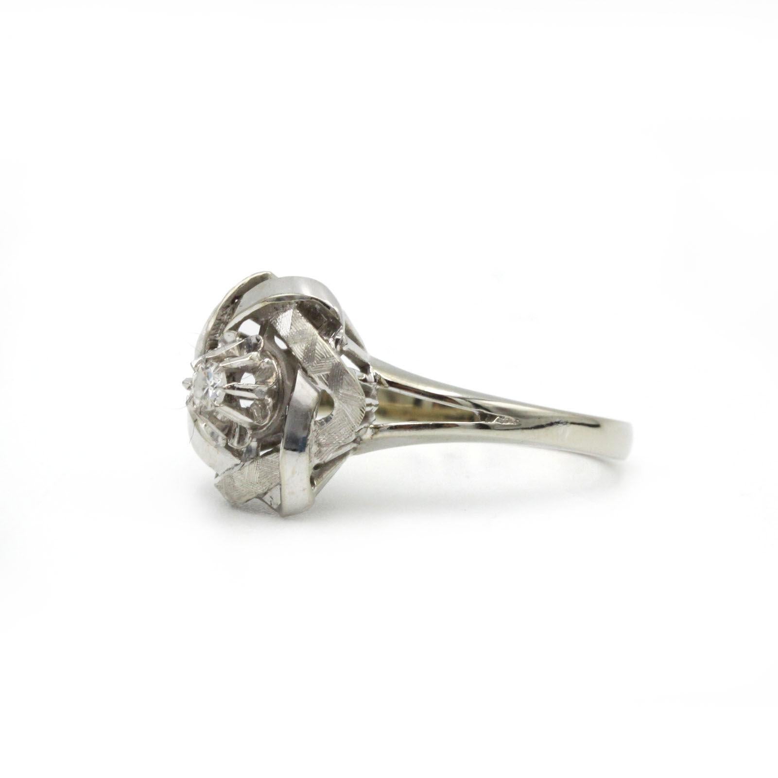 Dieser bezaubernde Vintage-Ring fängt mit seinem skulpturalen Blumenmotiv aus glänzendem 18-karätigem Weißgold die Romantik des Mid-Century-Designs ein. In seiner Mitte funkelt ein Brillant von ca. 0,09 Karat wie Morgentau inmitten von zart