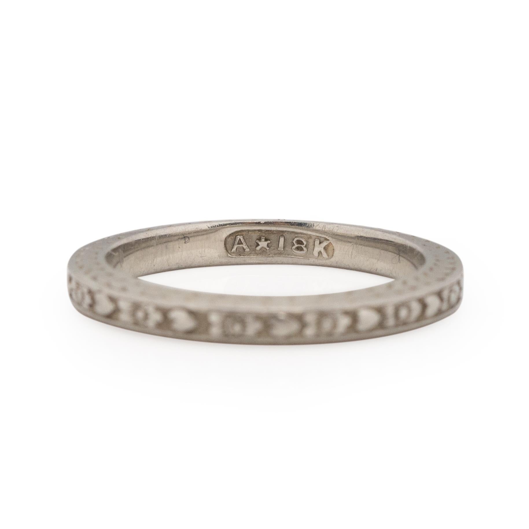 This piece is unique, fun and has a touch of whimsey. Crafted in 18K white gold this band has a beautiful heart and flower repeating pattern, that gives the overall piece a light feeling. The carved design is clean and deep, holding up to the test