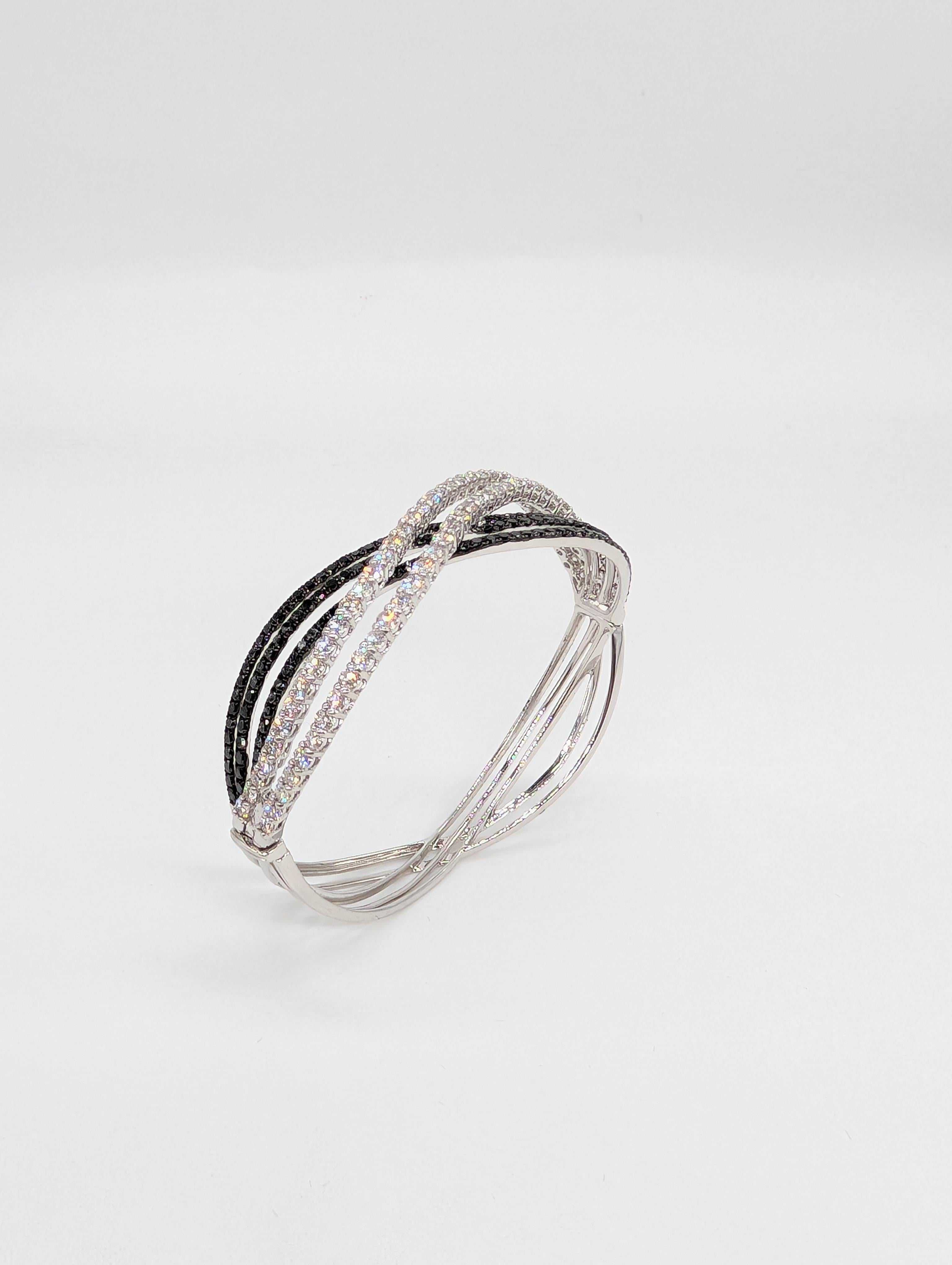 Questo squisito braccialetto a onde fantasia in oro bianco da 18 carati è un vero e proprio capolavoro, che mostra una straordinaria miscela di eleganza e audacia. Progettato con curve fluide e ondulate, il braccialetto è incastonato con 6,49 carati