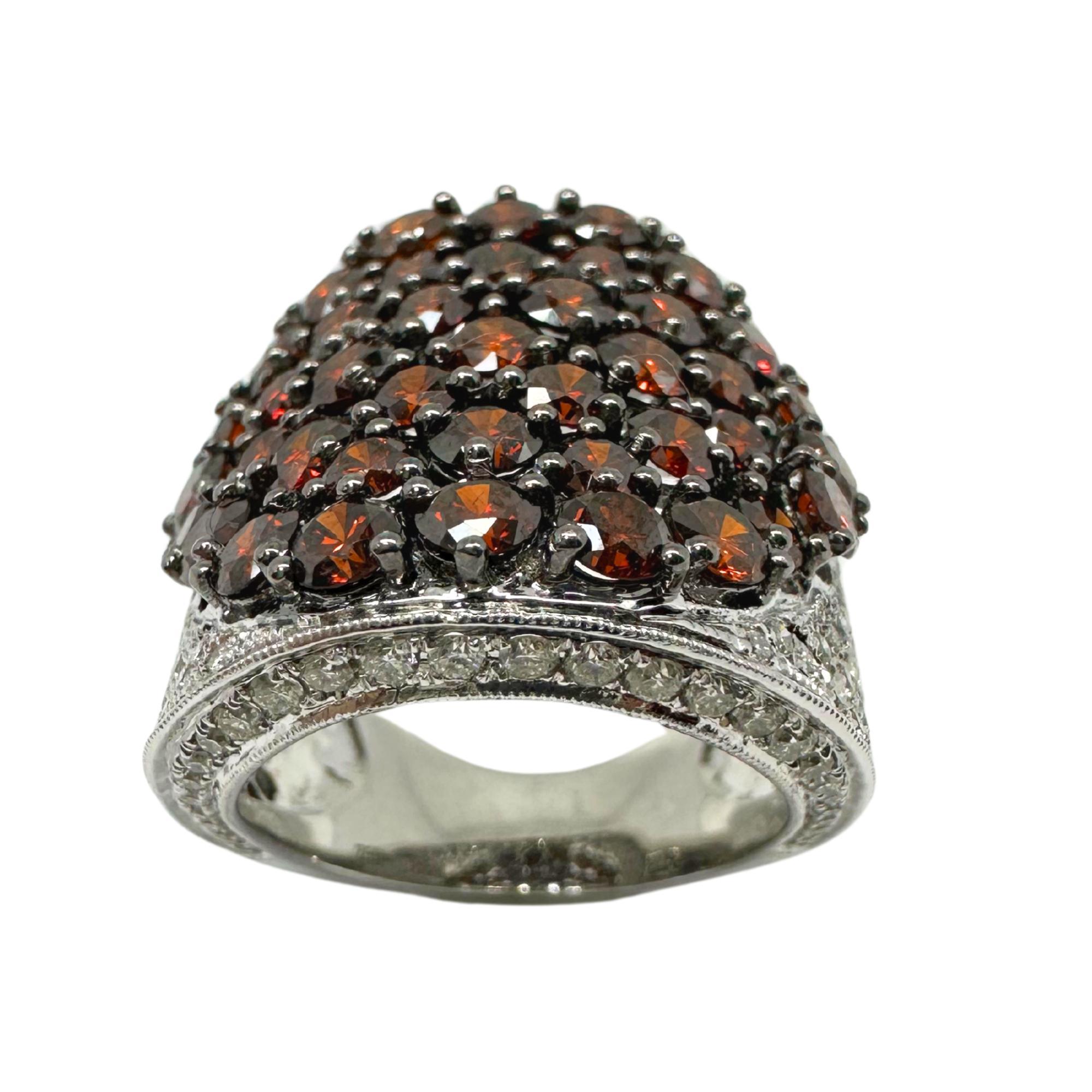 Questo anello a fascia larga, audace e lussuoso, presenta un'accattivante serie di diamanti bianchi e marroni incastonati in oro bianco 18 carati. I diamanti marroni, per un totale di 4,79 carati, mostrano una ricca tonalità marrone-arancio,