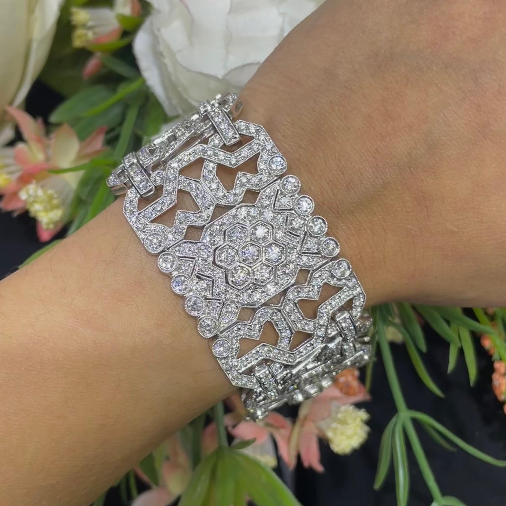 Questo splendido bracciale largo in stile Art Déco è realizzato in oro bianco da 18 carati e presenta uno squisito design con ben 14,20 carati di diamanti. I diamanti sono incastonati in modo intricato per creare un look lussuoso e senza tempo, con