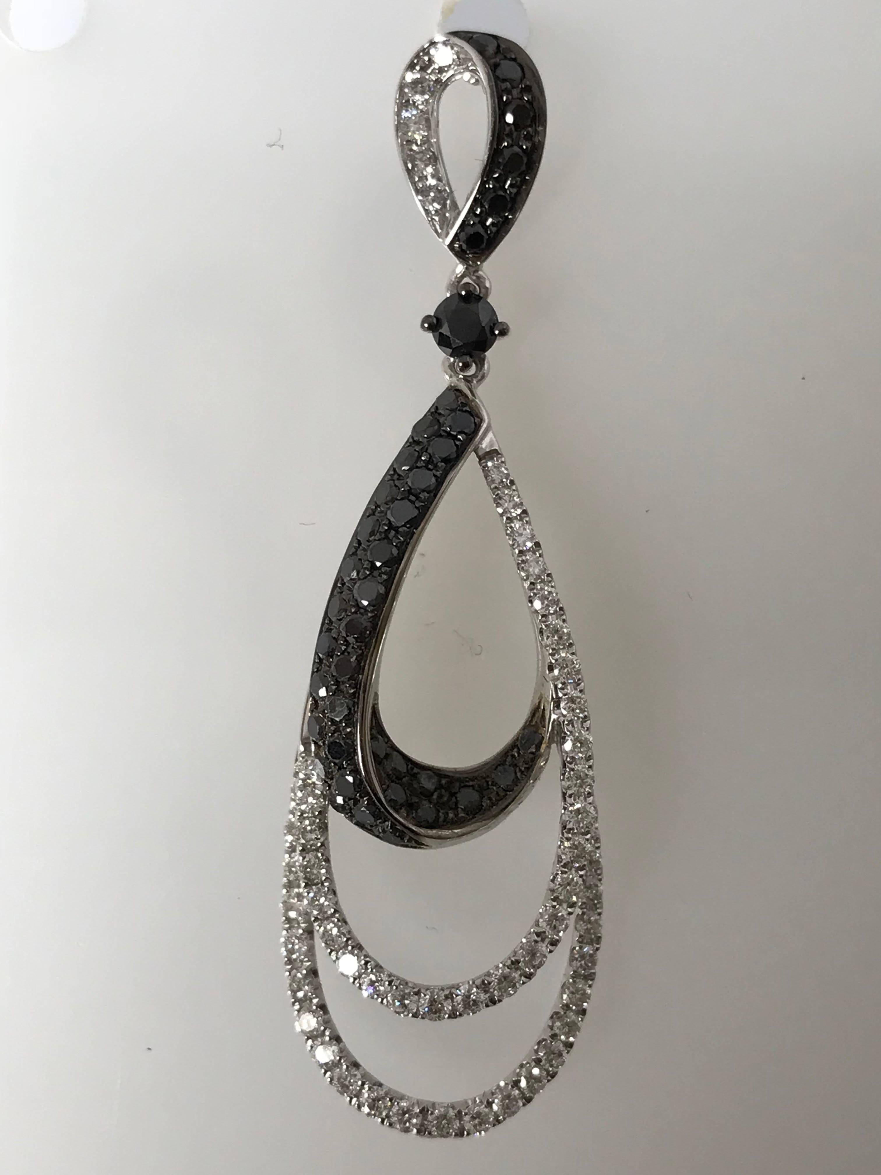 Handcrafted by a master jeweler in 18k white gold and 116 Diamonds 1.55 carats of round brilliant cut and 80 Black diamonds 1.69 cts perfectly matched, slightly graduated and secured with an attached backs.
This gorgeous twisted diamond earrings