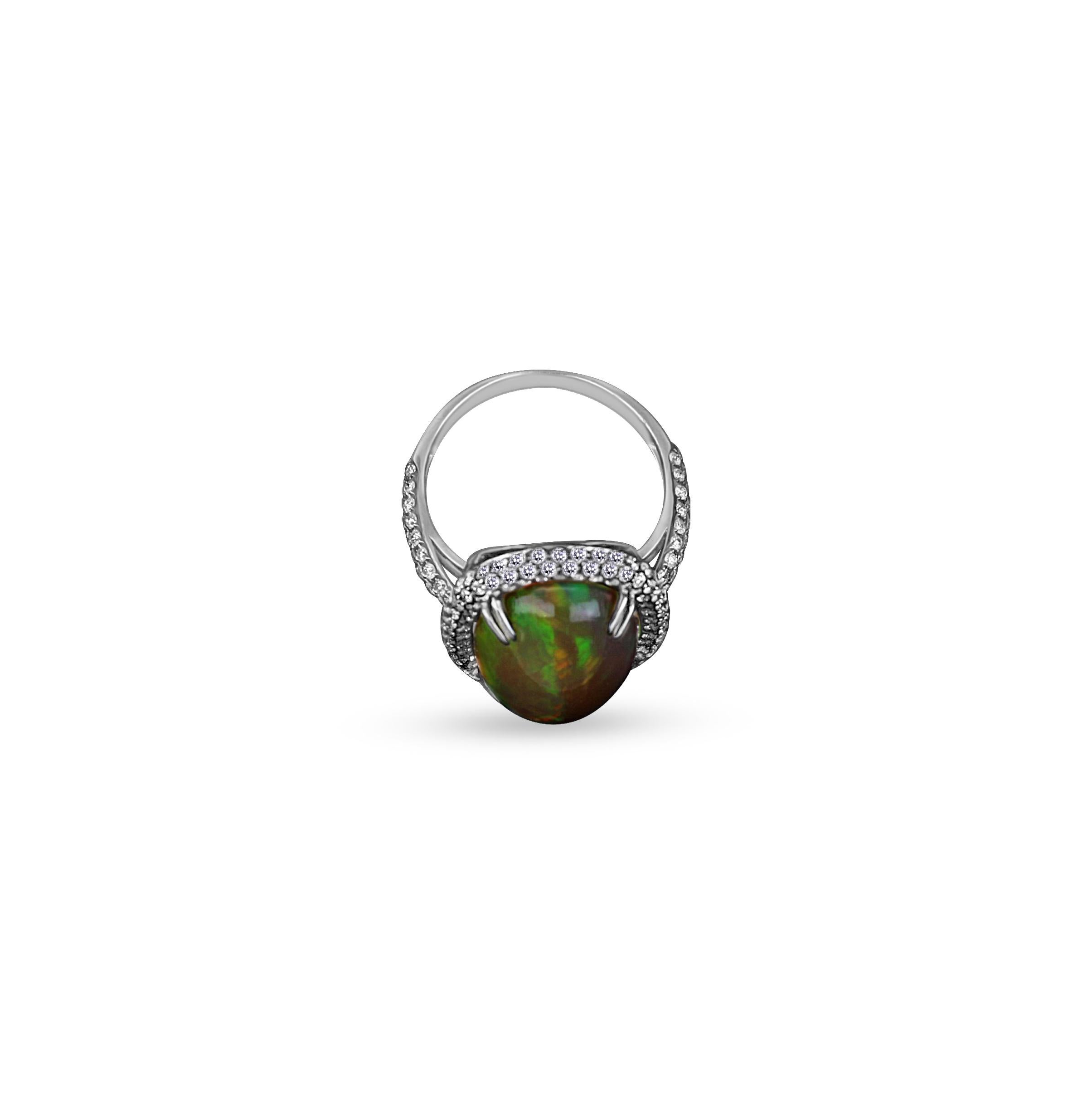 Behold the allure of a white gold ring, adorned with a captivating opal boasting green and brown glare. Featuring round cut diamonds all around that enhances its beauty, creating a harmonious blend of sophistication and natural elegance. 

Gross