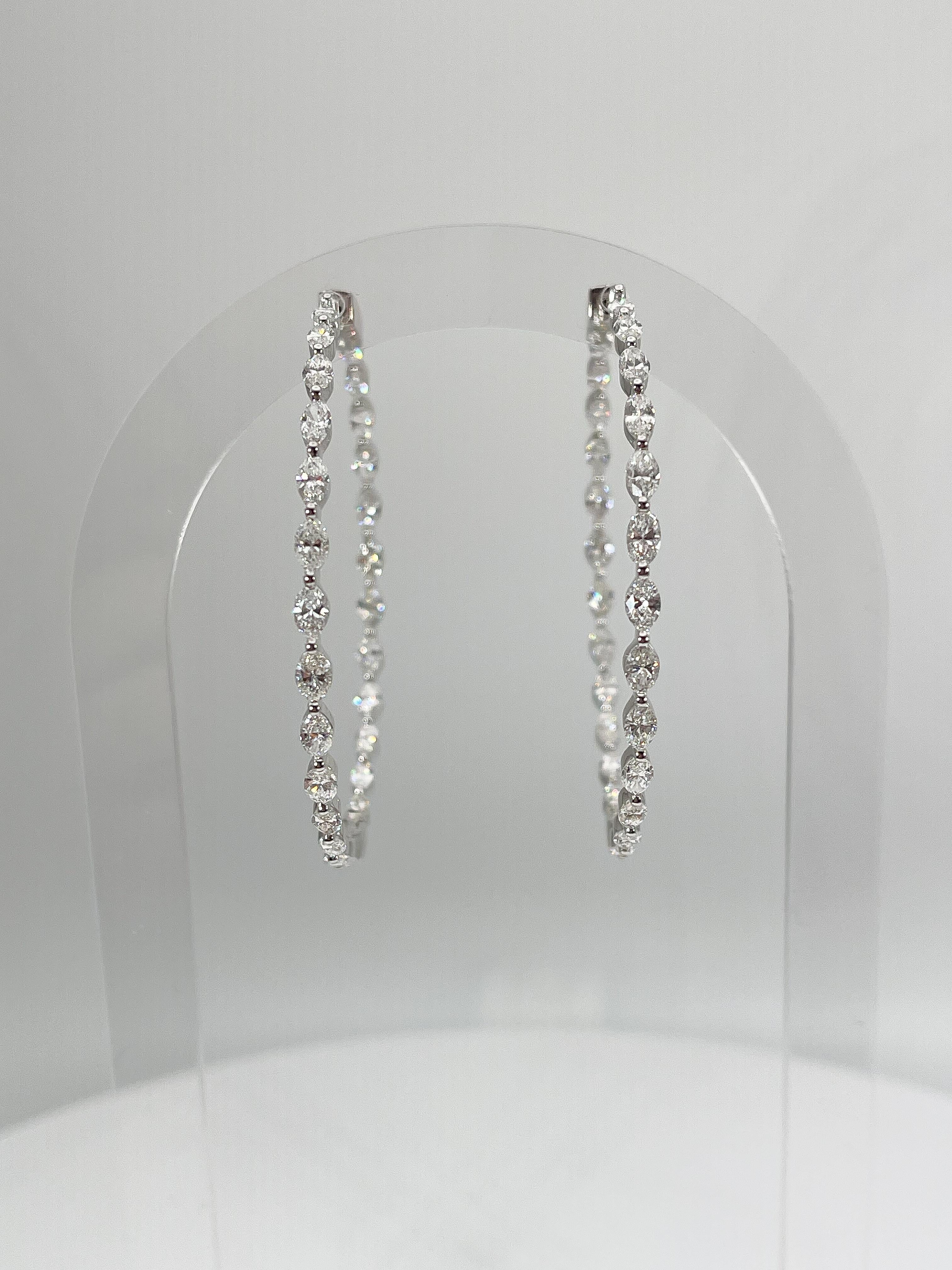 These 18K white gold x/large hoop earrings have 26 marquise cut diamonds going around each earring equaling 52 VS2 F-G color diamonds. These earrings have an inside diameter of 49.1 mm and have a total weight of 14.8 grams.