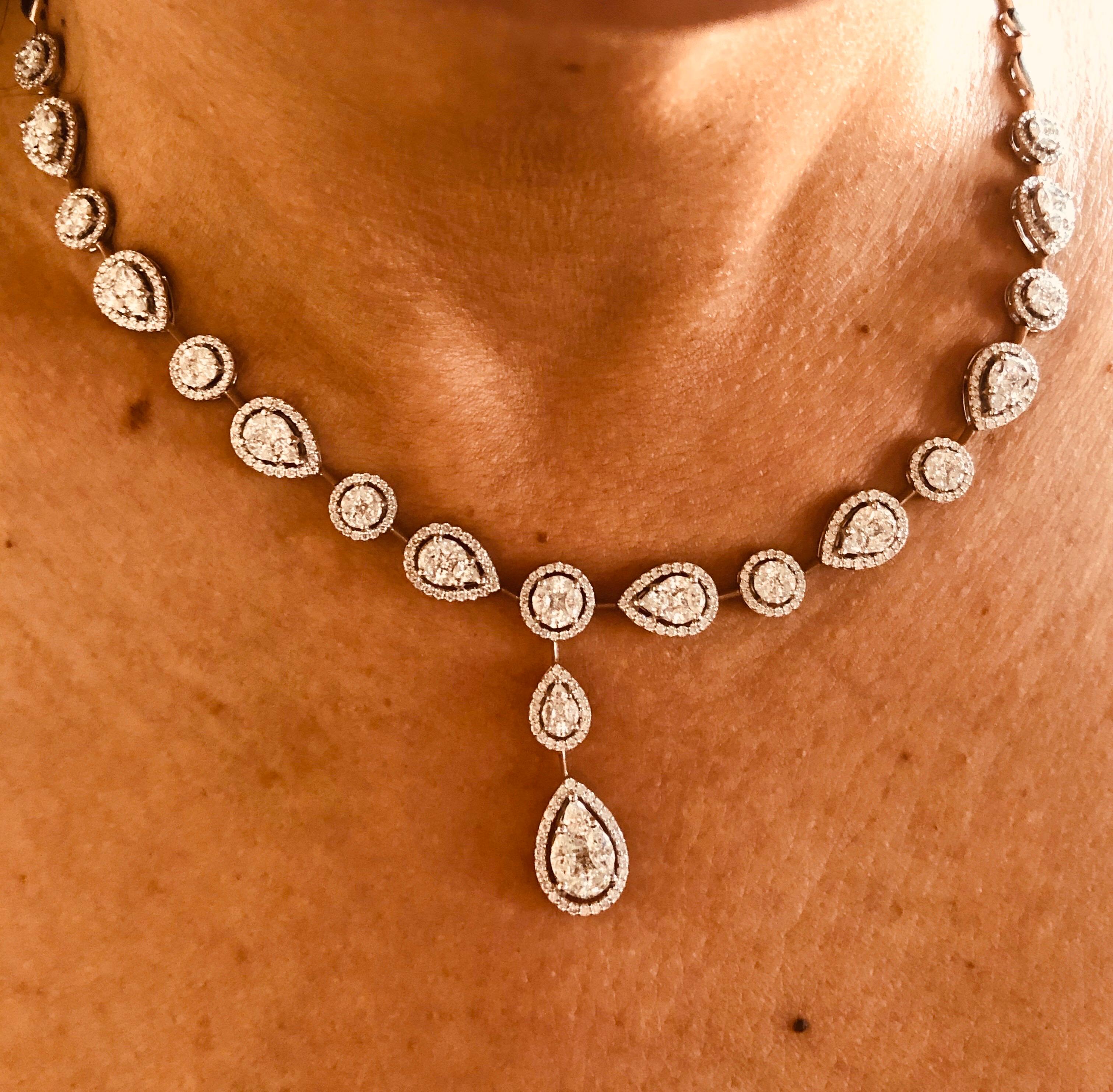 18K White necklace set with multi cut stones to create the illusion of a single round and pear shaped diamonds. The necklace is set half way of diamonds. The total weight of the piece is 9.17 carats. The color of the stones are F, the clarity is
