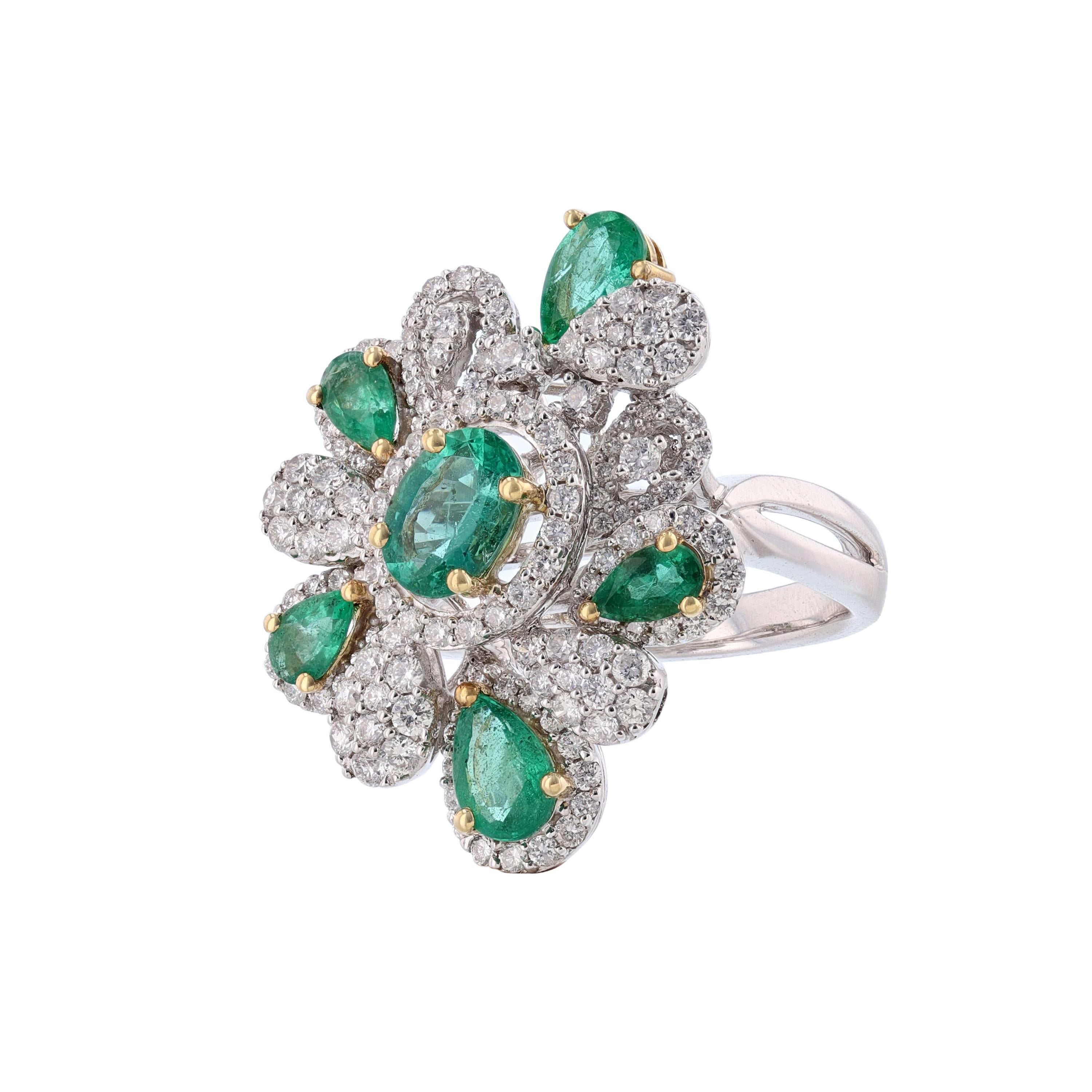This ring is made in 18K white and yellow gold and features 1 oval shape emerald and 5 pear shape emeralds weighing 1.96 carats. Also, the ring has 147 round cut diamonds weighing 1.12 carats. The stones are all prong set. With a color grade (H) and