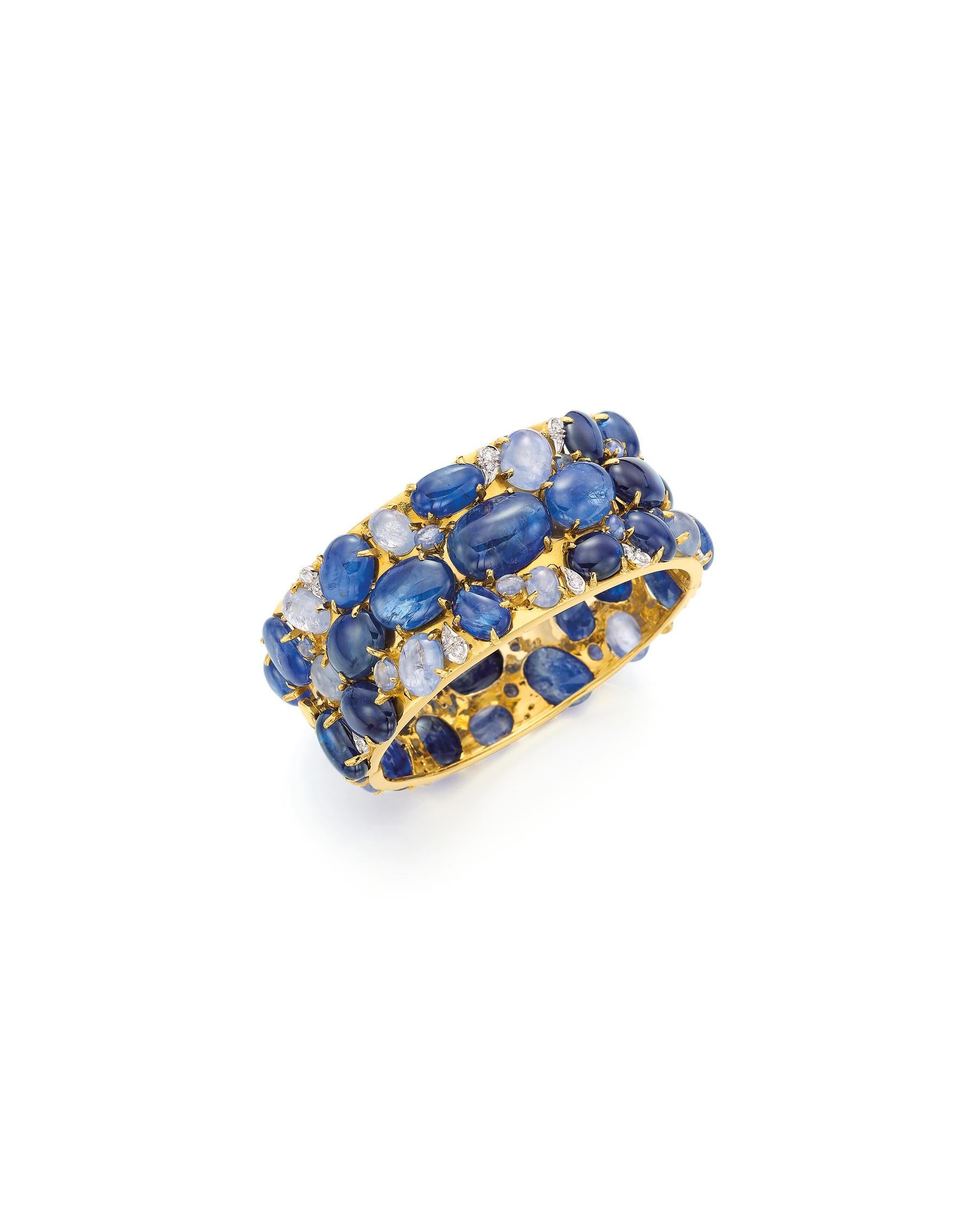 Beautifully designed as a hinged bangle
Set with oval-cut cabochon sapphires of various hues and sizes
Accented by round brilliant-cut diamond drops
Mounted in 18k white and yellow gold
Inner circumference 17.5cm (7 inches)
Featured in Bonhams