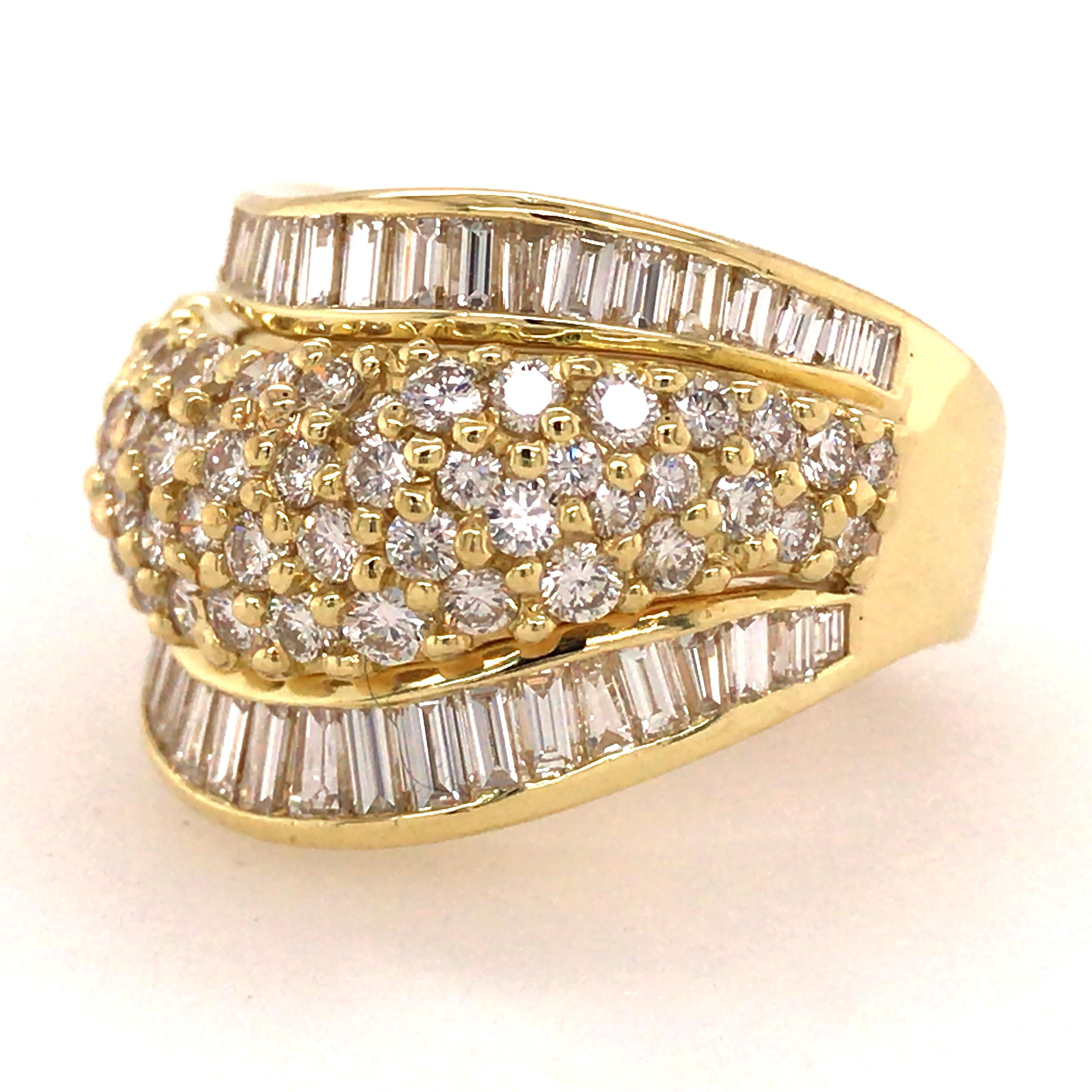 Wide Diamond Band in 18K Yellow Gold. (63) Round Brilliant Cut Diamonds weighing 1.52ct and (56) Baguette Cut Diamonds weighing 1.68ct for a total weight of 3.20 carats of D, G-H in color and VS in clarity.  The ring measures approximately 3/4 inch