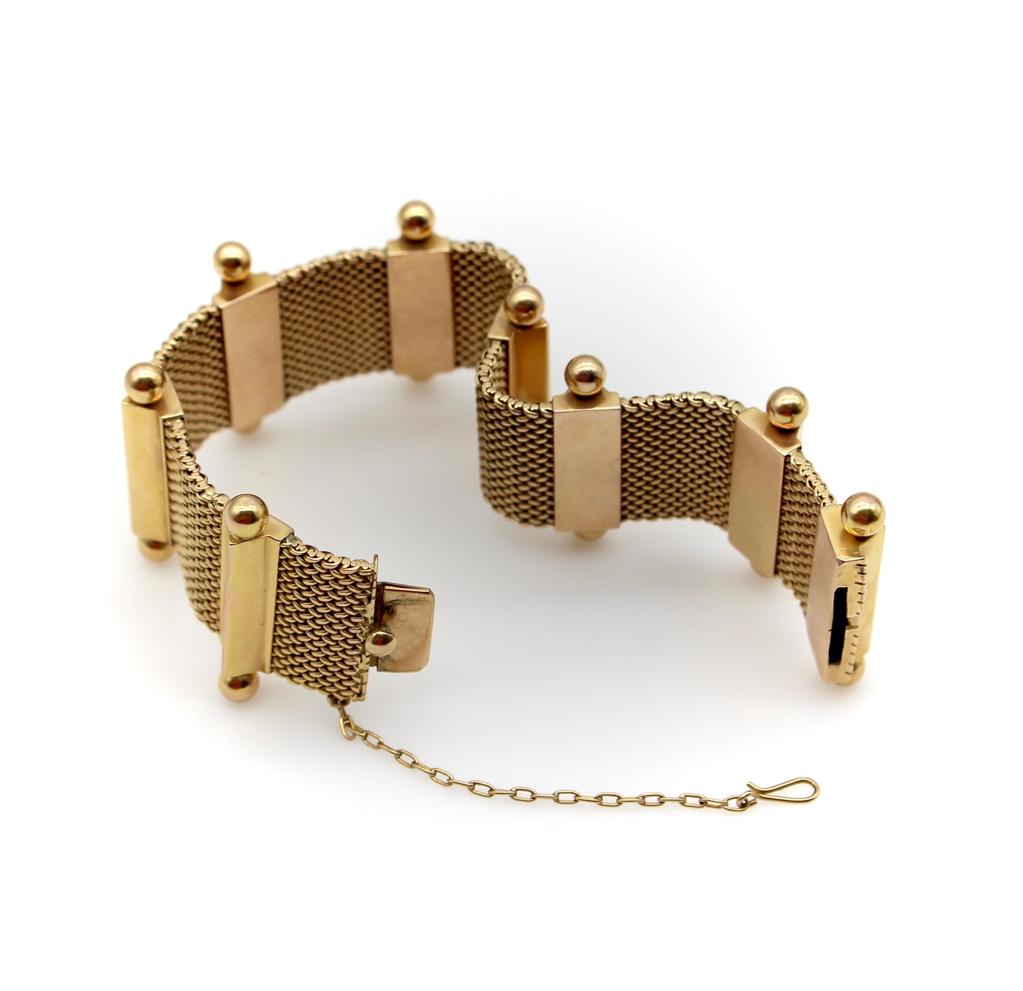 Ce bracelet en or 18 carats est composé de panneaux d'or tissés à la main, séparés par des barres triangulaires qui sont accentuées au sommet par des fleurons en forme de boule. Le bracelet présente plusieurs caractéristiques de conception qui le