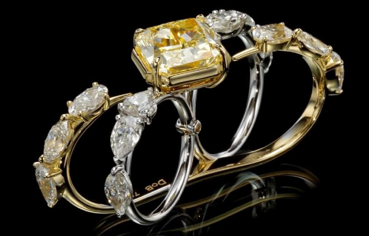 Ein wirklich bemerkenswerter Zwei-Finger-Ring mit einem fesselnden Fancy Yellow Radiant-Diamanten. Dieser außergewöhnliche Ring zeigt einen atemberaubenden 9,35 Karat Fancy Yellow Diamanten mit VS2 Reinheit, zertifiziert von GIA. Der strahlende