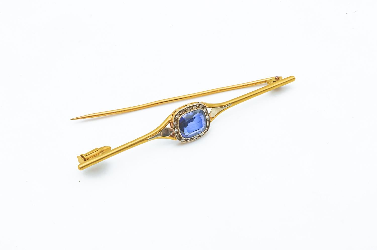 18 Carat Yellow and White Gold Brooch with Blue Sapphire and Diamonds 

Antique brooch in 18 karat yellow gold with a blue sapphire and 16 diamonds of 0.01 carat. To decorate a vest, a sweater or a tee-shirt. The Brooch can be used as a scarf
