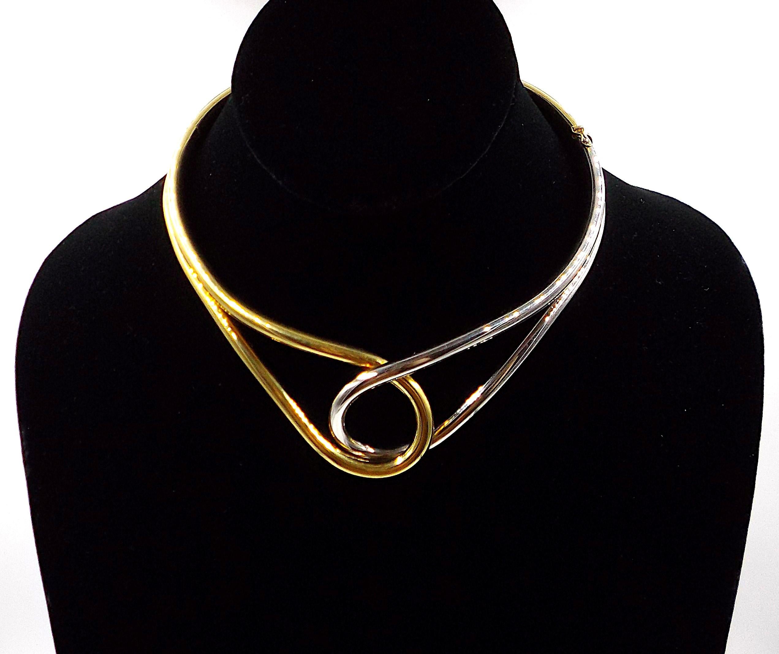 Designed as a polished yellow and white gold loop. At widest the choker measures ap. 1 1/2 inches, inside measurement is ap. 14 inches, weight is ap. 83.1 grams. Stamped 750, IOMI.