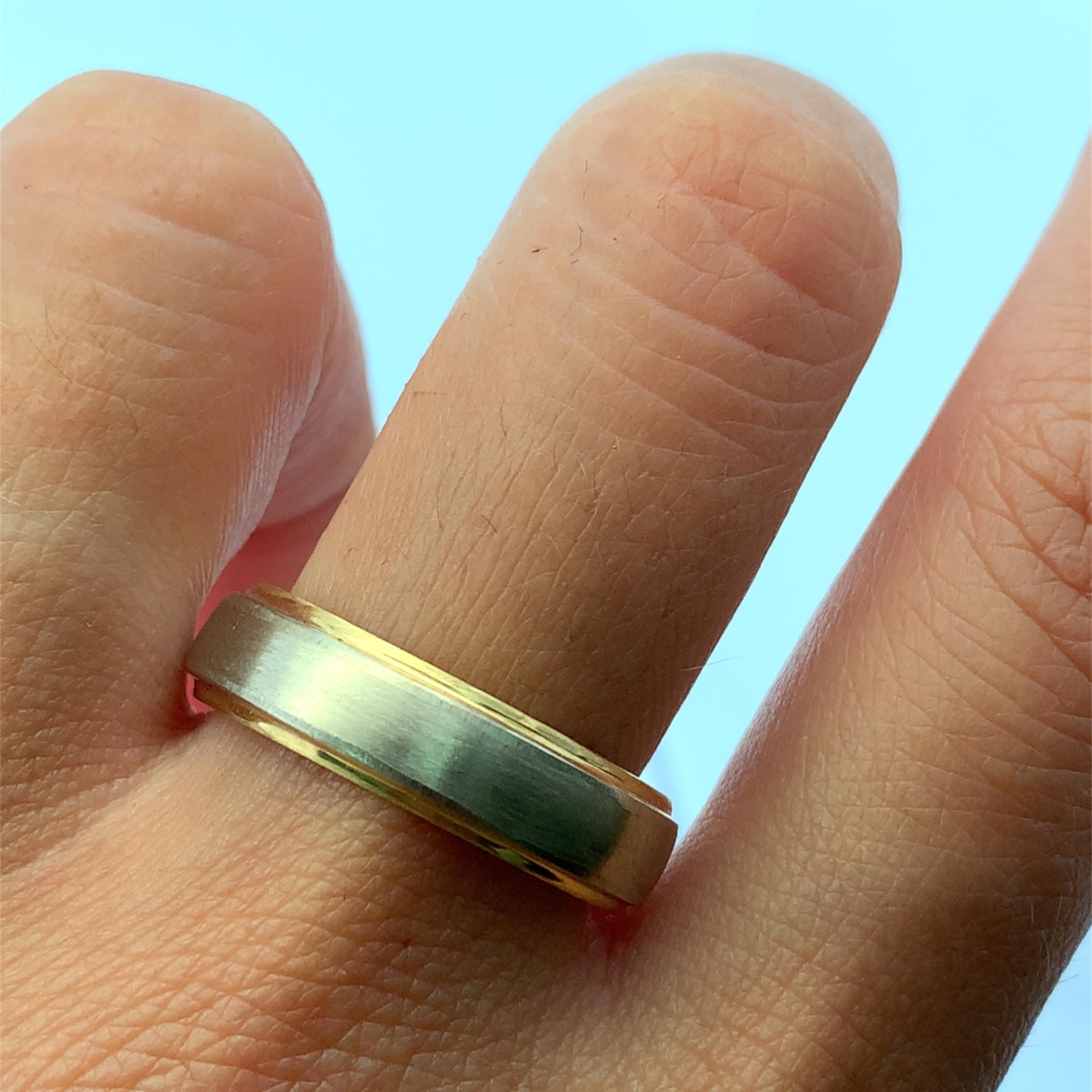 Eleva il tuo stile quotidiano con questo classico  Fede nuziale 18k bianca e gialla satinata con finitura opaca, larghezza 6,5, 7,6 g.  Realizzato in oro giallo lucido, questo anello presenta un centro a contrasto che aggiunge un tocco di moderna