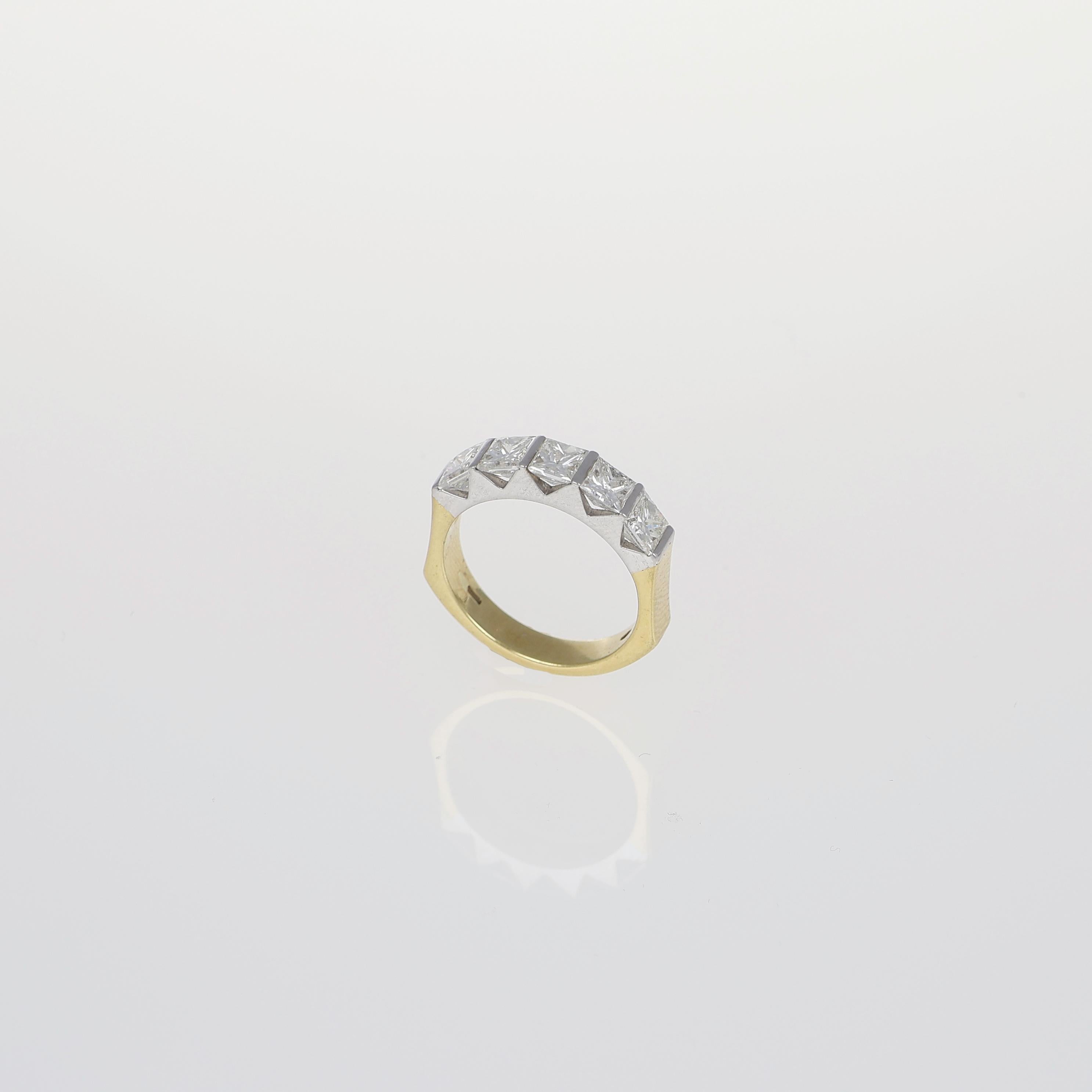 D'une conception audacieuse et architecturale, cette bague en or jaune et blanc 18 carats présente une structure géométrique frappante accentuée par des diamants de taille princesse totalisant 2,36 carats. Les tons dorés contrastés rehaussent
