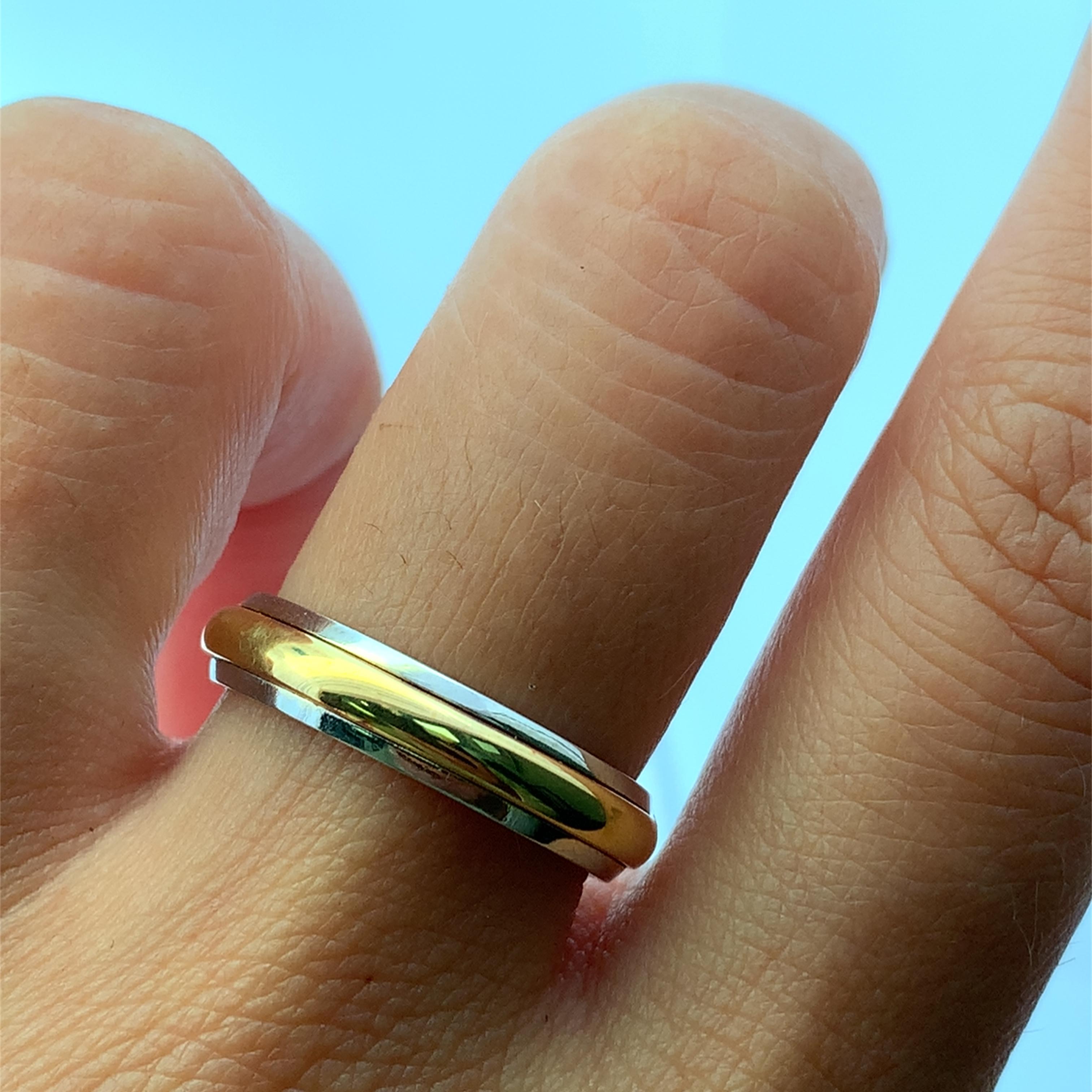 Dieser zweifarbige Goldring ist ein klassisches Symbol für Engagement und zeigt eine nahtlose Verschmelzung von Edelmetallen. Das schlanke, polierte Design verfügt über ein strahlendes 18k  Gelb- und Weißgold in der Mitte, flankiert von Bändern aus