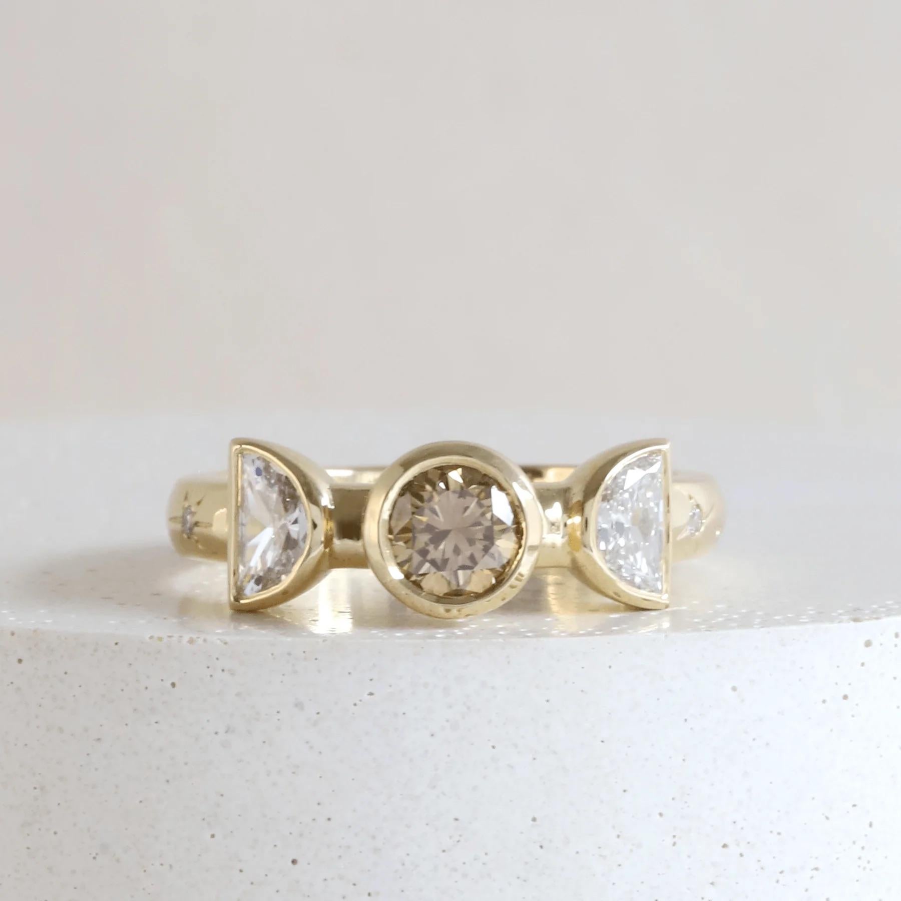 Harvest Moon Ring

18K Yellow Bezel Diamond Ring set with West Australian origin Medium Champagne/Brown Diamond with natural Half-Moons sides & diamond-set Hand Engraved Stars on the shank.

18K AKARA People+Planet Yellow Gold*, Serial Number