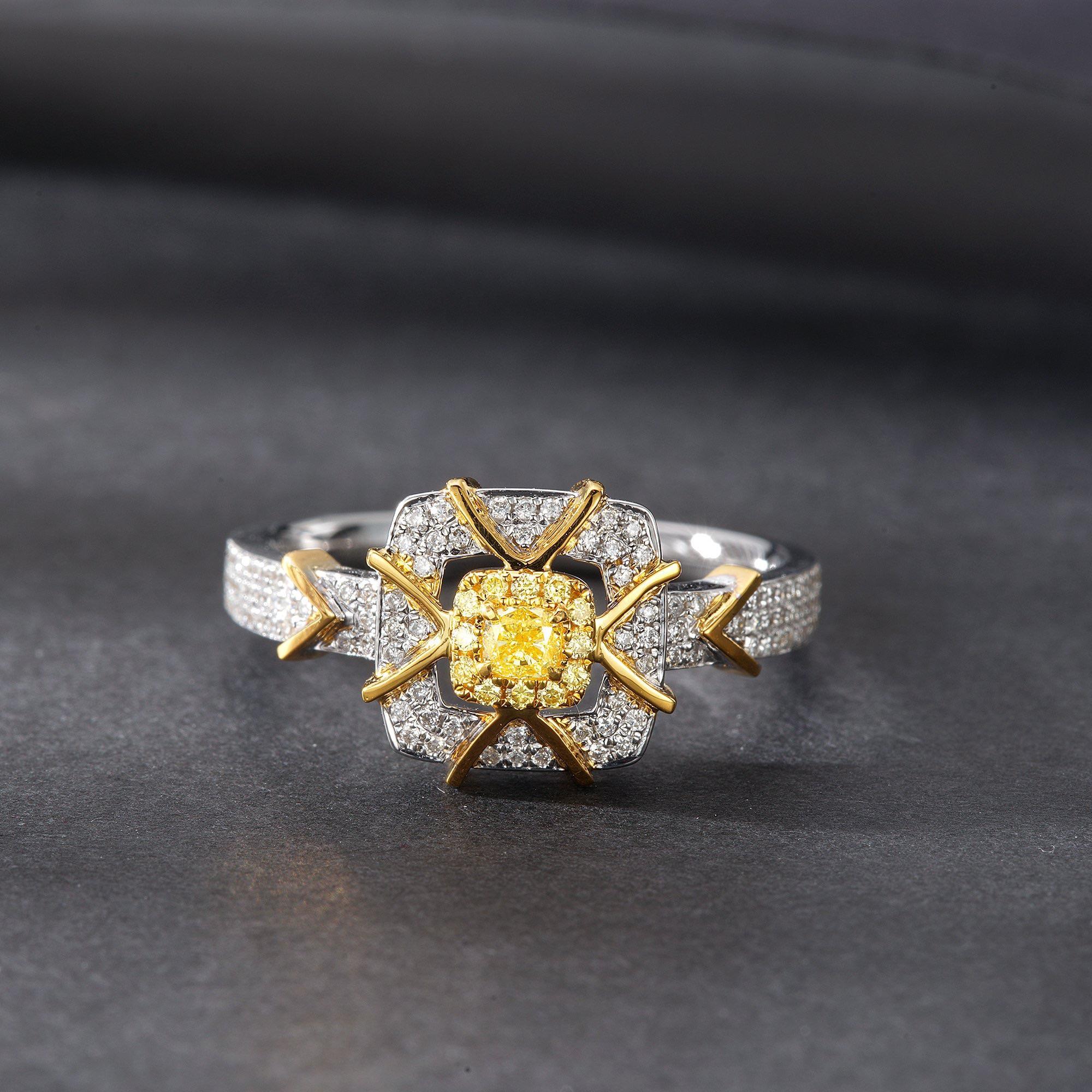 Chef-d'œuvre de luxe inspiré par la nature, cette remarquable bague de cocktail en or jaune 18 carats présente un design bicolore sophistiqué à taille coussin, rehaussé de diamants naturels lumineux. Le diamant central de 0,09ct est encadré par des