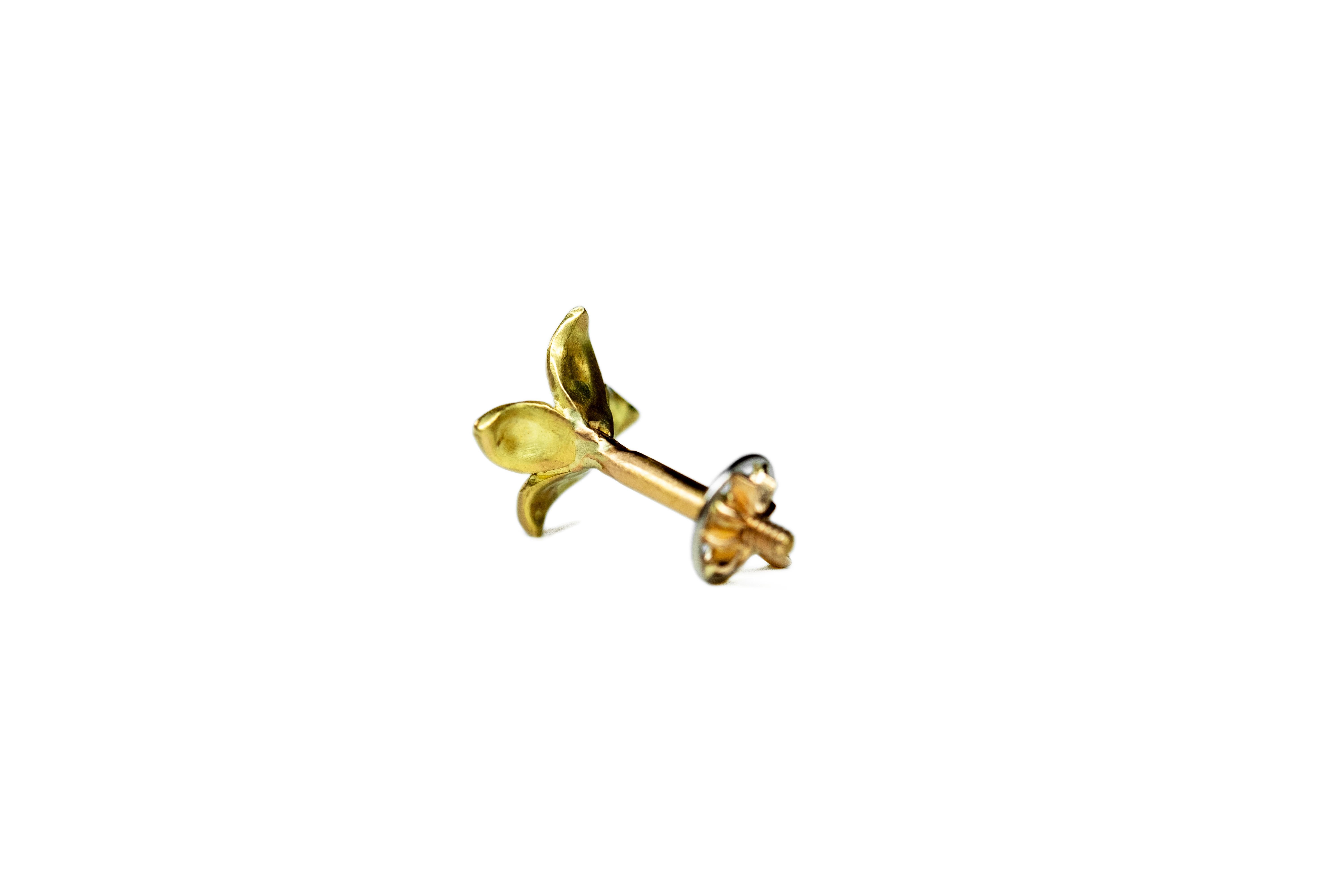 Blumenförmiger Ohrring, komplett handgefertigt aus 18-karätigem Gelbgold und Diamanten mit kanadischem Schliff.

Die Blume wird an der Rückseite mit einem Schrauben in den Stern geschraubt. Die Schraube ist handgefertigt. Wir empfehlen, sie sanft zu