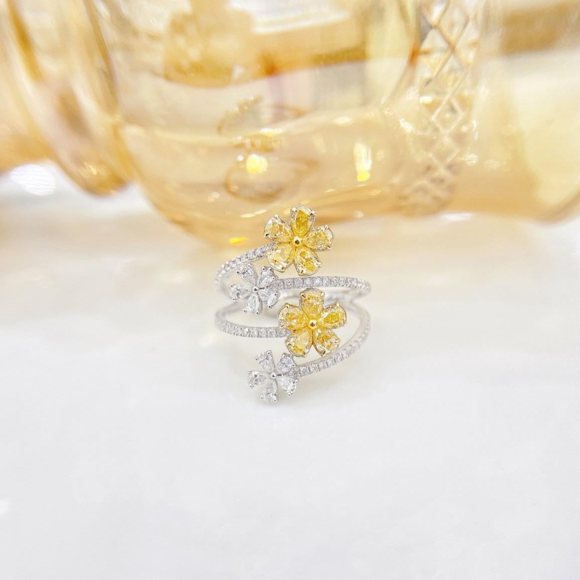 Chef-d'œuvre de luxe inspiré par la nature, cette époustouflante bague en or jaune 18 carats d'inspiration florale présente un hypnotisant motif de double fleur incrusté de diamants naturels. Le diamant central de 1,05ct est entouré de 0,50ct de