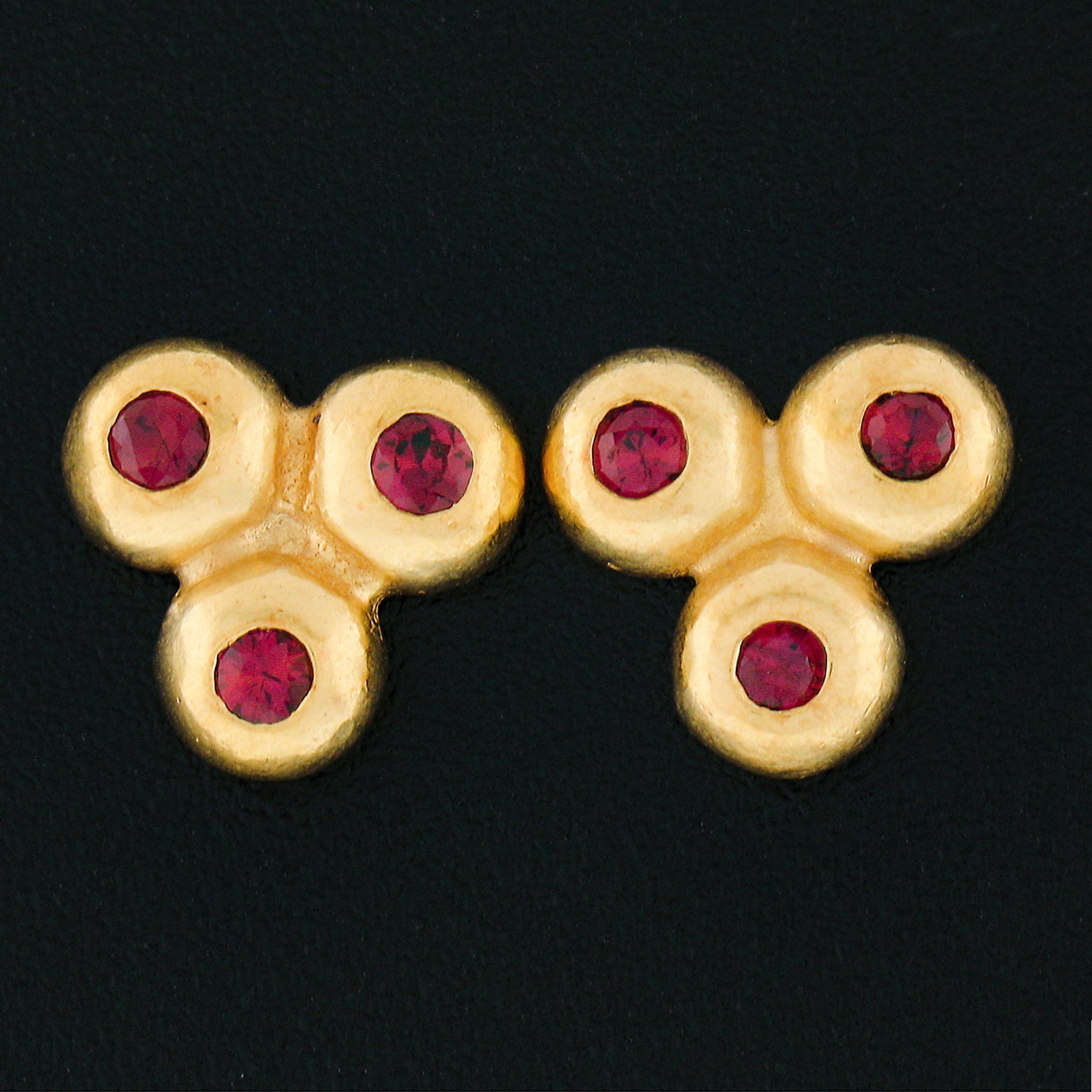 Here we have a lovely pair of stud earrings that are crafted from solid 18k yellow gold. The earrings each feature a cluster of 3 bezel set natural ruby stones. The round brilliant cut rubies are well matched with a gorgeous vivid red color, and