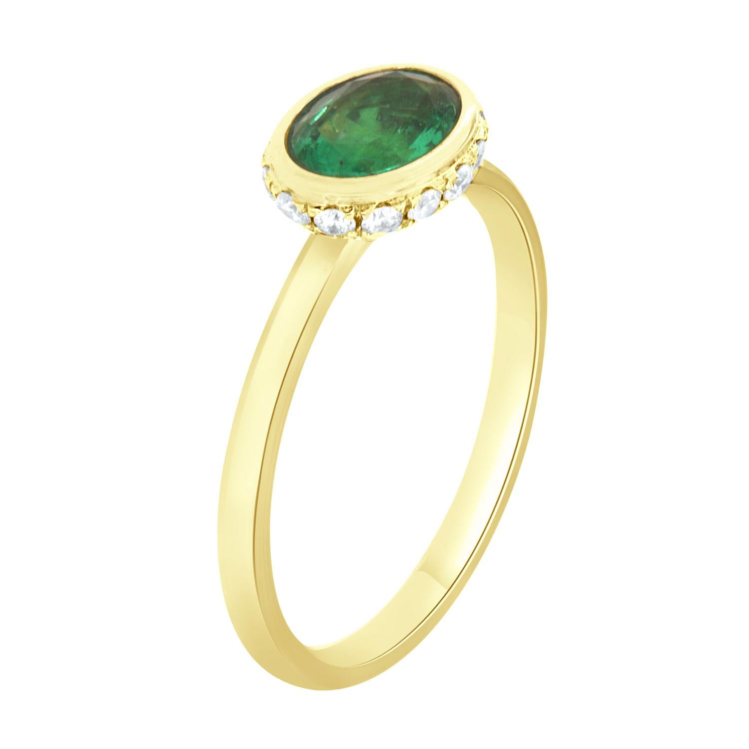 This 14k White gold delicate ring features a 0.78 Carat vibrant green oval shape emerald bezel set East-West style. Sixteen (16)Brilliant round diamonds are micro-prong set in a hidden halo on the crown to create the sparkle look every woman is