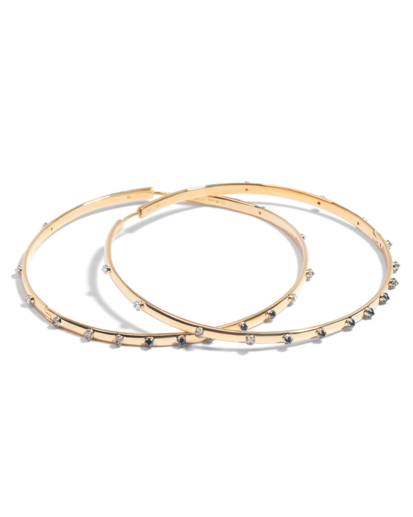Intention: Savoring the Details

Design: An ombre' constellation of 2mm diamonds ranging from white to salt and pepper to black makes a welcome and subtle appearance in these streamlined hoops. Inverted in 18k white gold settings, the usually hidden