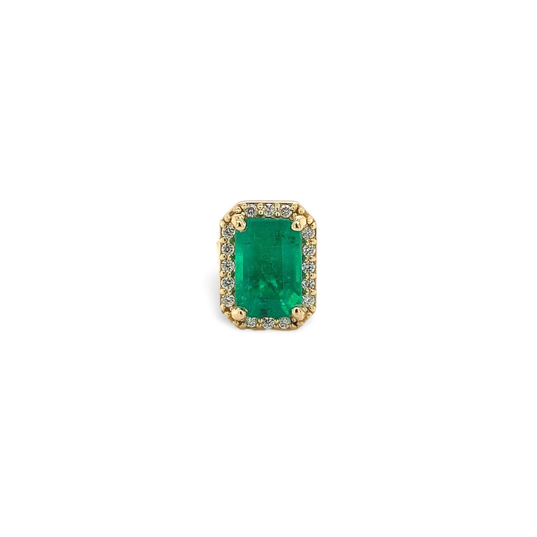 A pair of 18K yellow gold genuine earth mined emerald stud earrings with diamond halos. The emerald cut emeralds measure about 6mm x 4mm and have medium dark color and fine clarity. The emeralds weigh 1.16 carats total. There are 32 tiny round