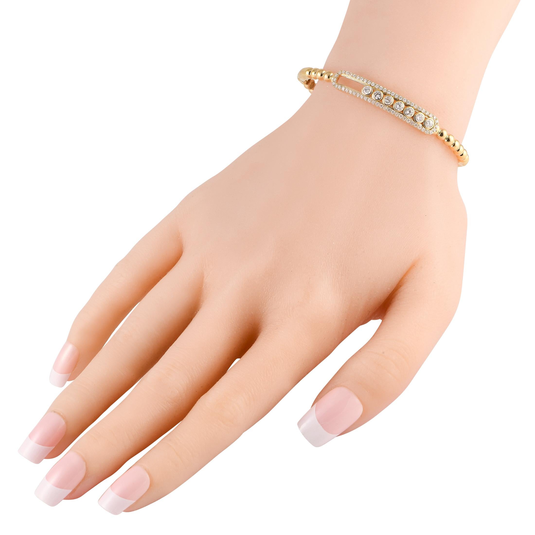 Delicate and dynamic in design, this sophisticated 18K yellow gold bangle bracelet is an impeccable piece that will never go out of style. Elevated by 1.20 carats of sparkling diamonds, it measures 6.75 long and includes secure tab insert clasp