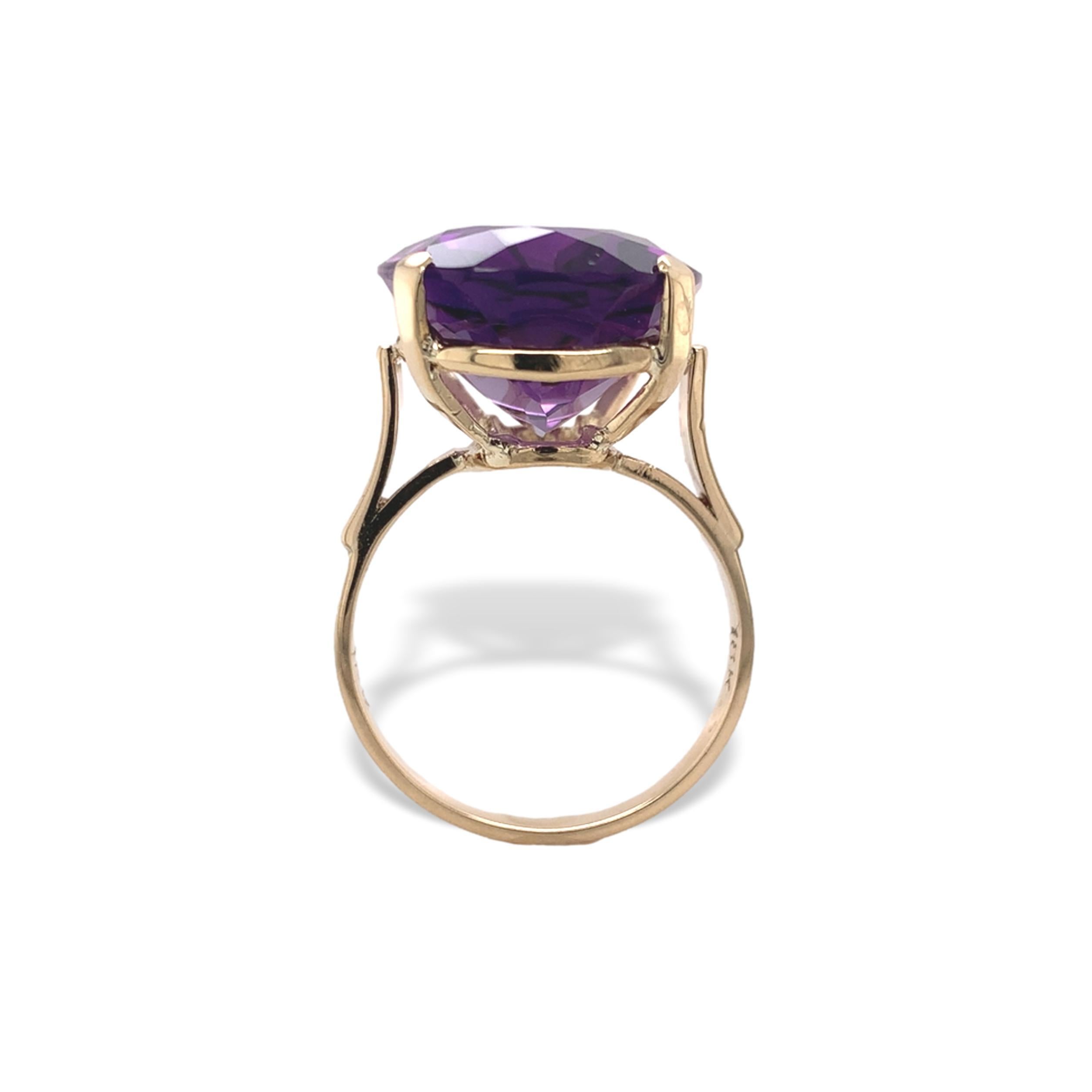 An 18K yellow gold ring featuring an oval cut genuine earth mined amethyst gemstone. The ring is hand fabricated with gold tube wire and other elements. The amethyst has medium purple color. The amethyst weighs 13.98 carats and measures about 19mm x