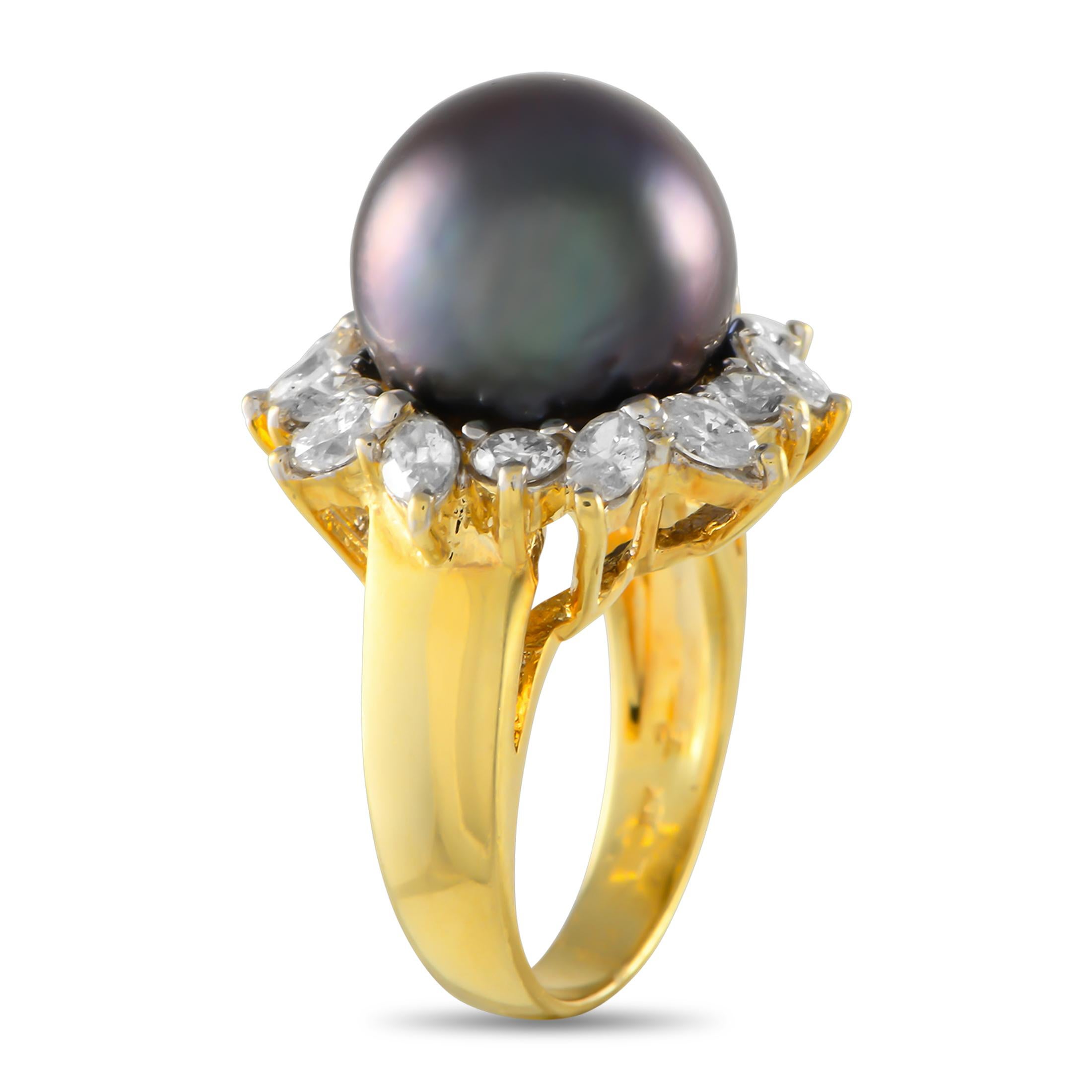 Glamour meets drama. A large and lustrous 13mm Tahitian pearl crowns this estate jewelry. The perfectly round dark-colored pearl sits high on an 18K yellow gold band. It is encircled by captivating salt-and-pepper diamonds, enhancing and