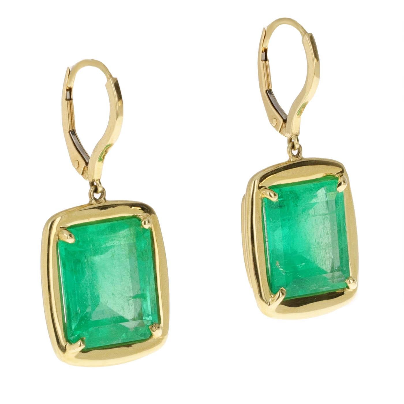 18K yellow gold Colombian emerald dangle earrings featuring two striking emeralds with a combined weight of 17.90 carats. Each gemstone is expertly bezel-set in a handcrafted 18-karat yellow gold setting that perfectly embraces and secures the