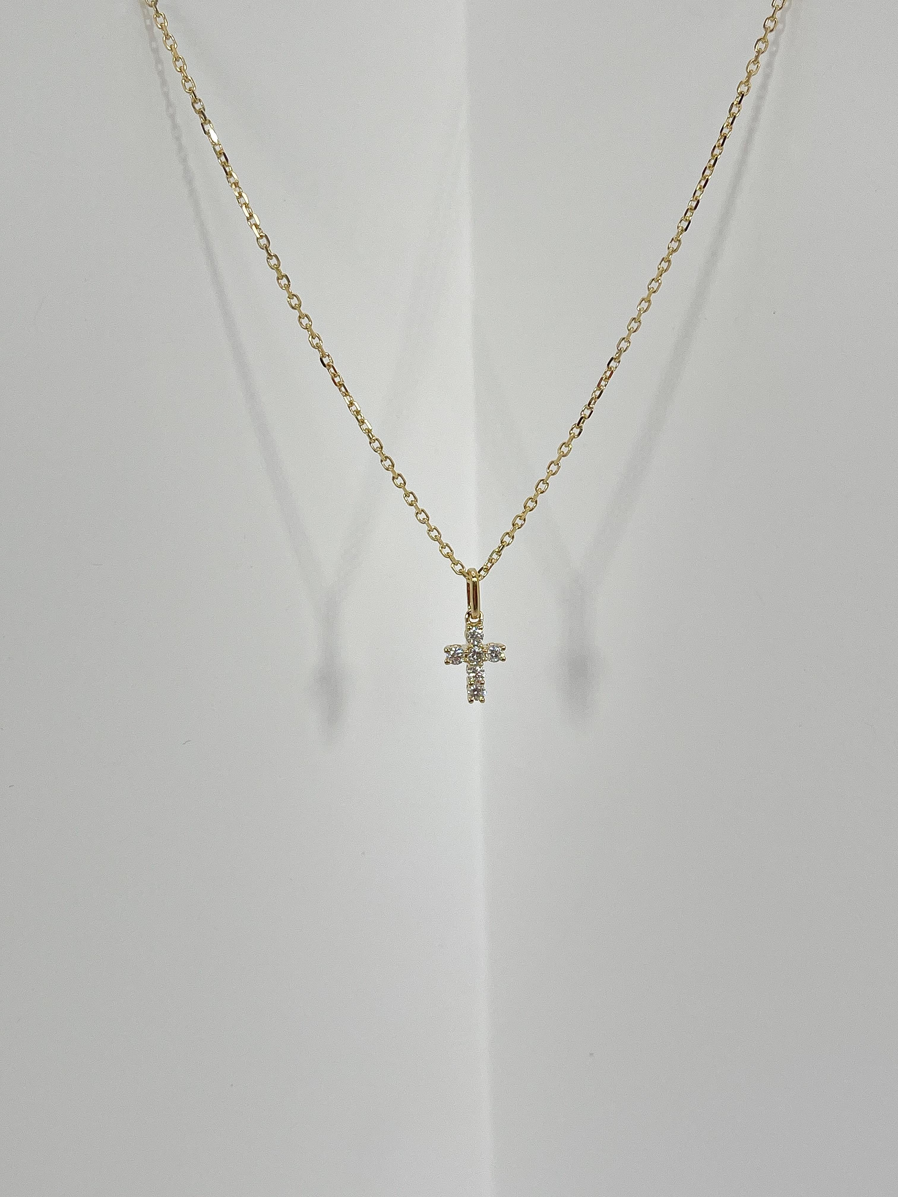 18k yellow gold .20 CTW diamond cross pendant necklace. The diamonds in the pendant are all round, pendant measures to be 8.7mm x 6.5mm, has a lobster clasp to open and close, pendant comes on an 18-inch diamond cut cable chain, and has a total