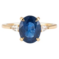 Anillo de cóctel de oro amarillo de 18 quilates con zafiro oval de 2,25 ct y tres diamantes en forma de pera