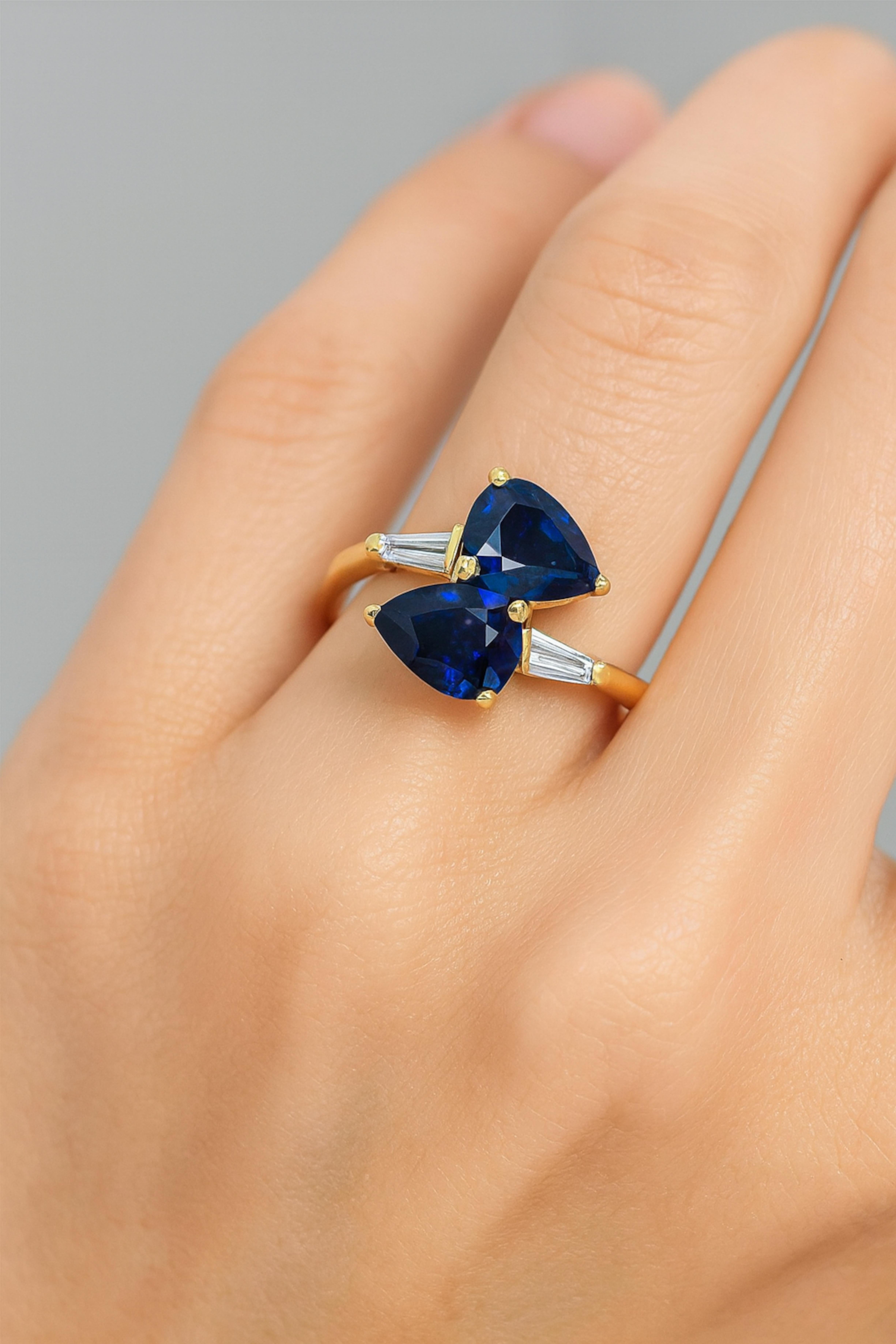 18K Gelbgold 3 Karat Saphir und Diamant Bypass Ring

Dieser elegante Bypass-Ring besteht aus zwei blauen Saphiren in Birnenform mit einem Gesamtgewicht von ca. 3,00 Karat, gefasst in 18-karätigem Gelbgold. Jeder Saphir wird von einem spitz