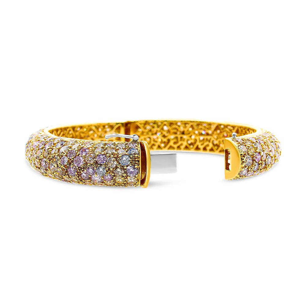 Multiple rows of rich, fancy colored diamonds create a warm, yet decadent glow in a bangle that makes for a magnificent statement. This piece epitomizes our superior craftsmanship, with a colorful array of yellow, pink, green, and champagne diamonds