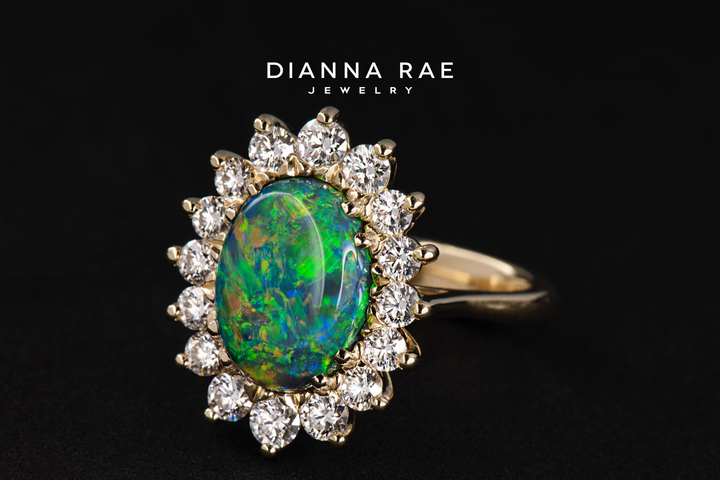 See the northern lights with your own eyes in this Dianna Rae Original, Aurora! Crafted in 18k yellow gold, this ring features a mesmerizing 3.69ct Lightning Ridge black opal in the center and is framed by a cluster of ideal-cut round brilliant