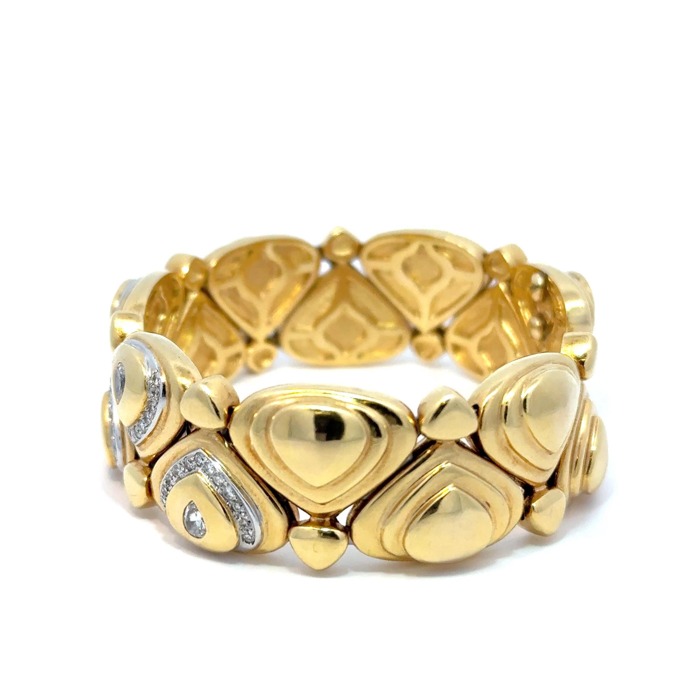 Ce bracelet manchette est une pièce audacieuse et luxueuse, réalisée en or jaune 18 carats massif. Présentant un motif dynamique de gouttes et de motifs géométriques, il met en valeur environ 4,00 carats de diamants taillés en brillant. Les diamants