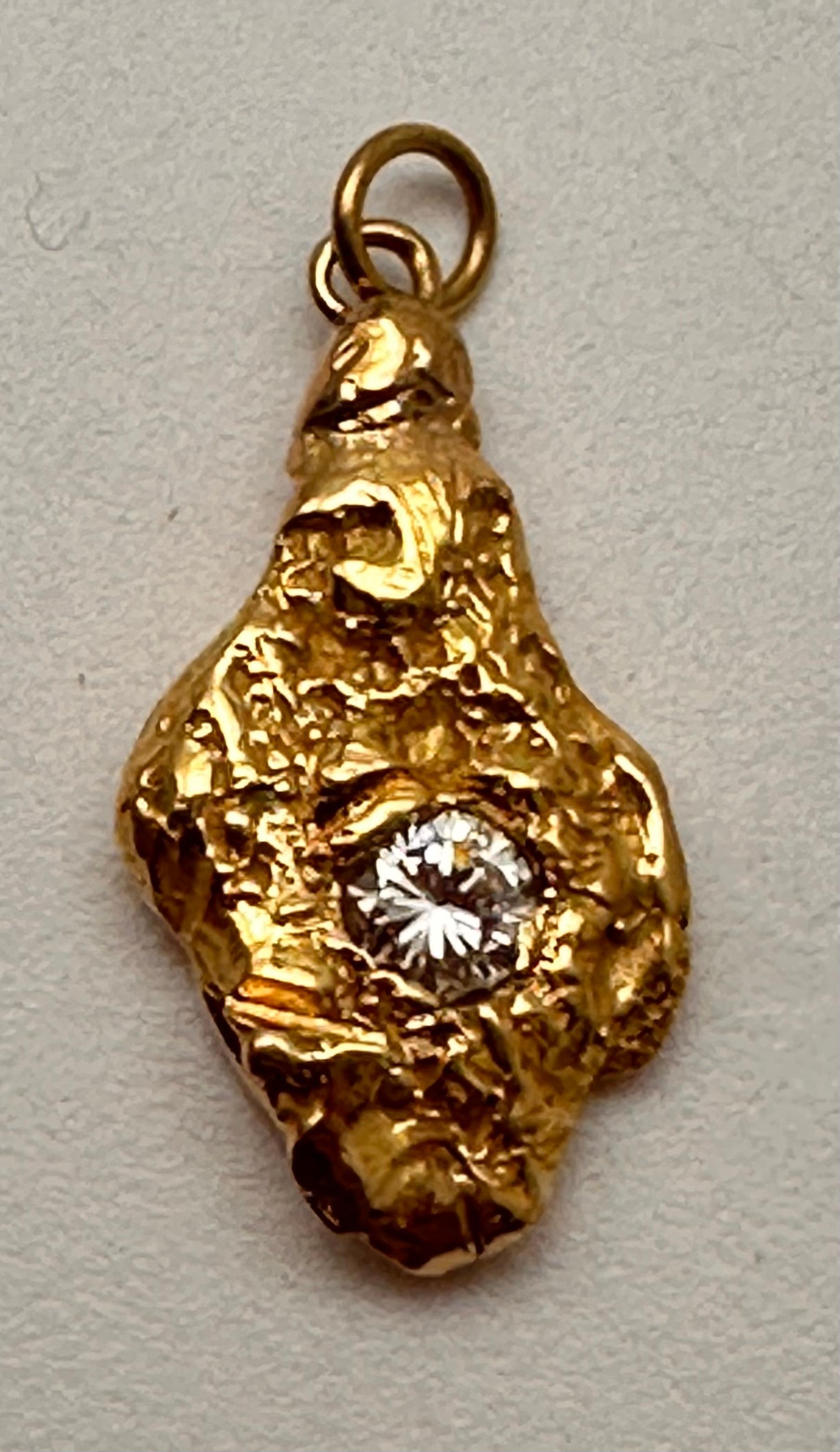 This exquisite handmade pendant showcases a stunning approx. 4mm round sparkly diamond set in 18k yellow gold. The freeform nugget shape adds a touch of uniqueness to this piece, while the white/colorless round sparkly diamond complement the yellow