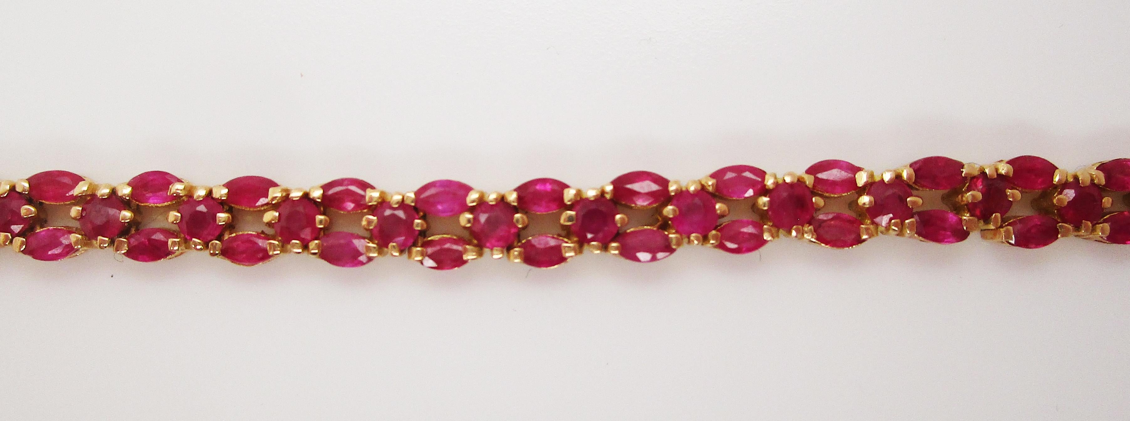 This is a gorgeous line bracelet in 18k yellow gold featuring five carats of lovely bright red rubies! The bracelet features a unique layout of round and marquise-shaped rubies. The bracelet is flexible, comfortable, and easy to wear. The