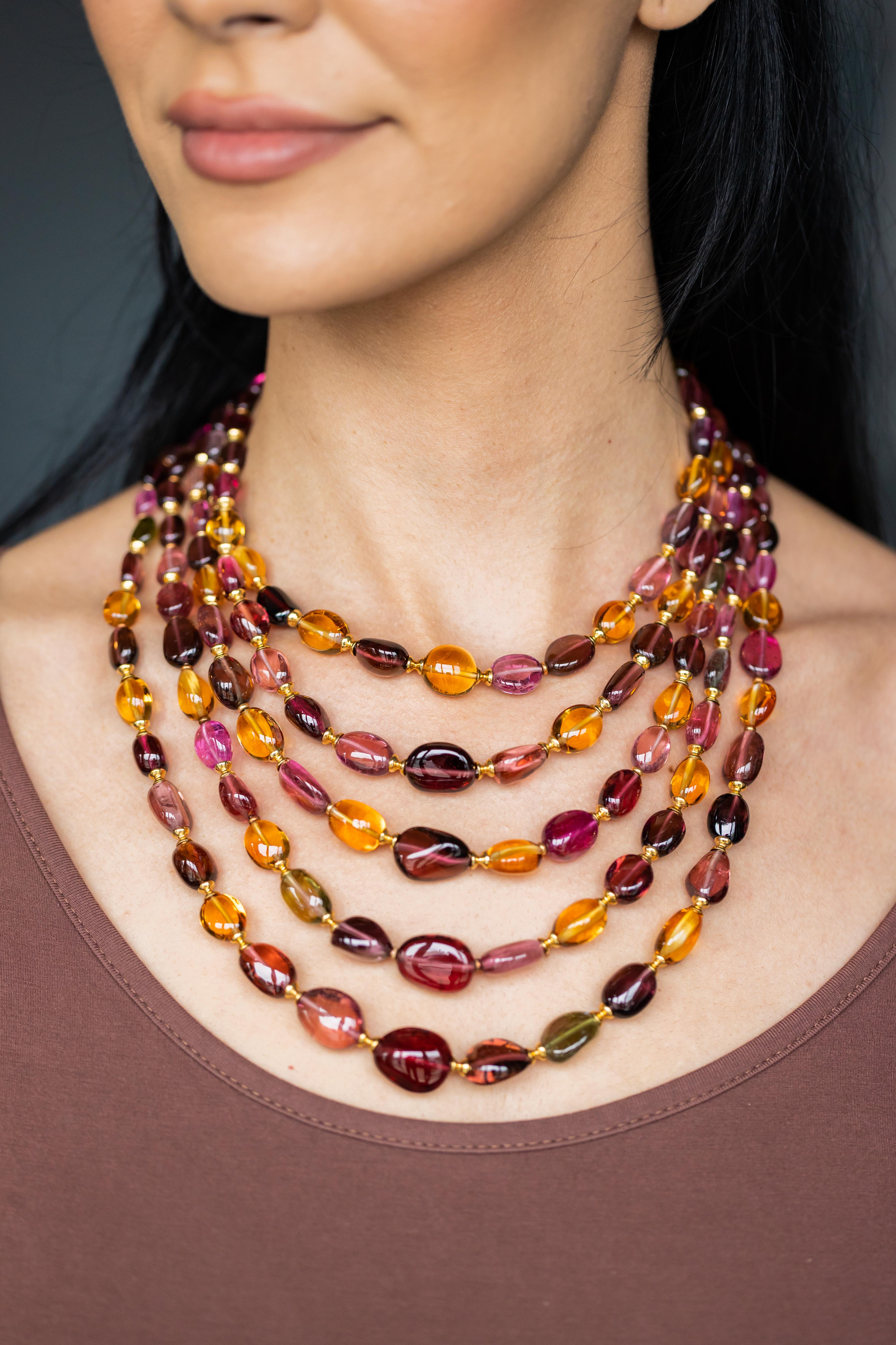 Plongez dans la beauté vibrante de l'automne avec cet exquis collier à cinq brins en or jaune 18 carats, une création enchanteresse des designers renommés de Syna. Cette pièce luxueuse présente un ensemble de perles de tourmaline et de citrine