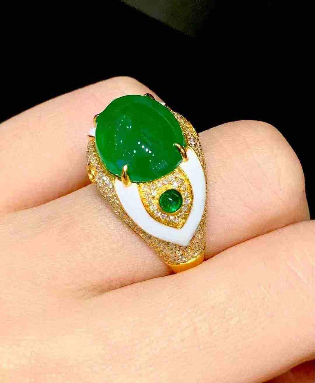Exquise bague en or jaune 18 carats mettant en valeur une superbe émeraude naturelle de 6,00 carats en son centre. La pierre précieuse d'un vert éclatant est magnifiquement complétée par un halo et une bande de diamants pavés brillants, ajoutant de