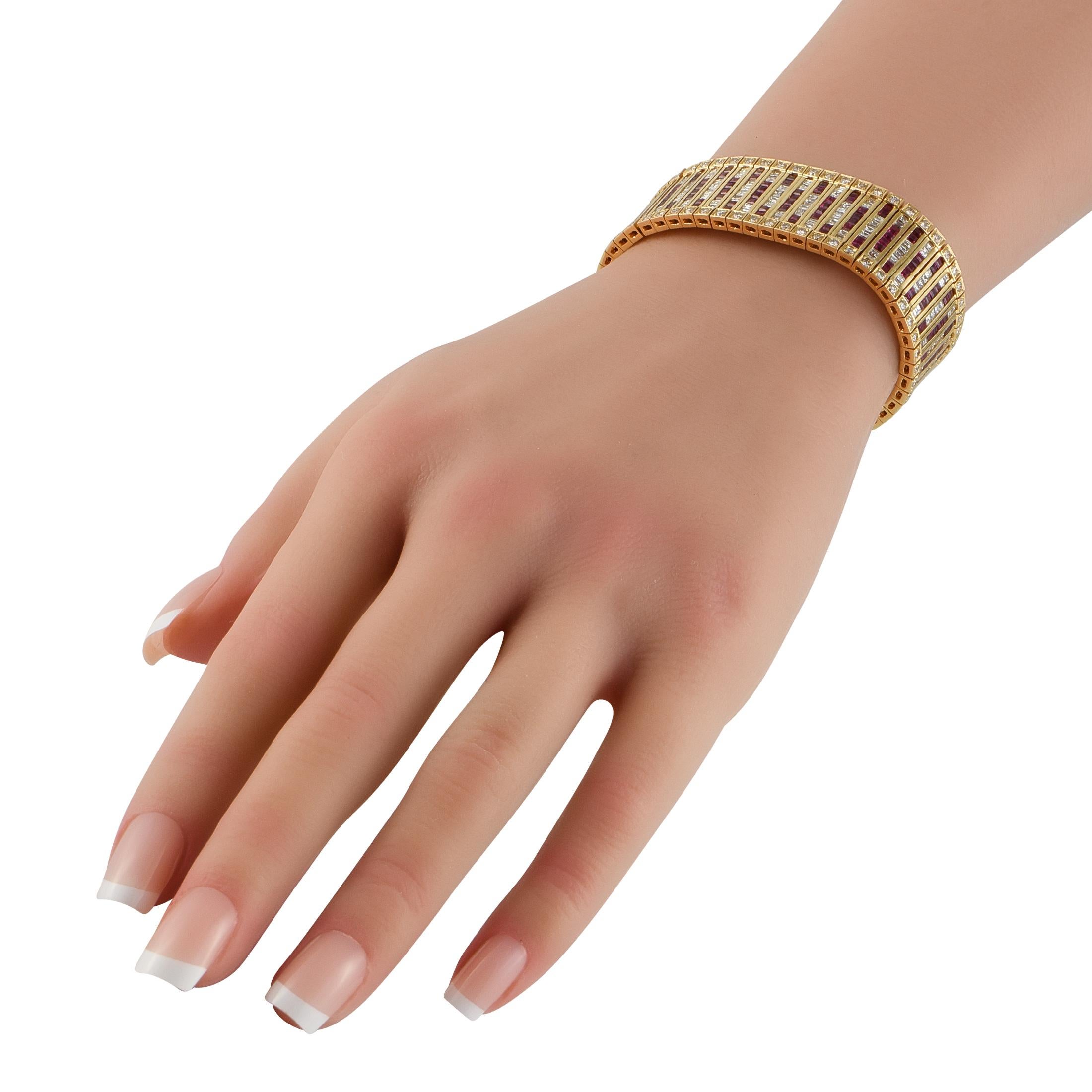 Un superbe design géométrique fait de ce bracelet un ajout opulent à toute collection de bijoux. Une monture en or jaune 18 carats mesurant 6,25 cm de long met en scène cet accessoire exquis. Au centre, des pierres précieuses en rubis d'un poids