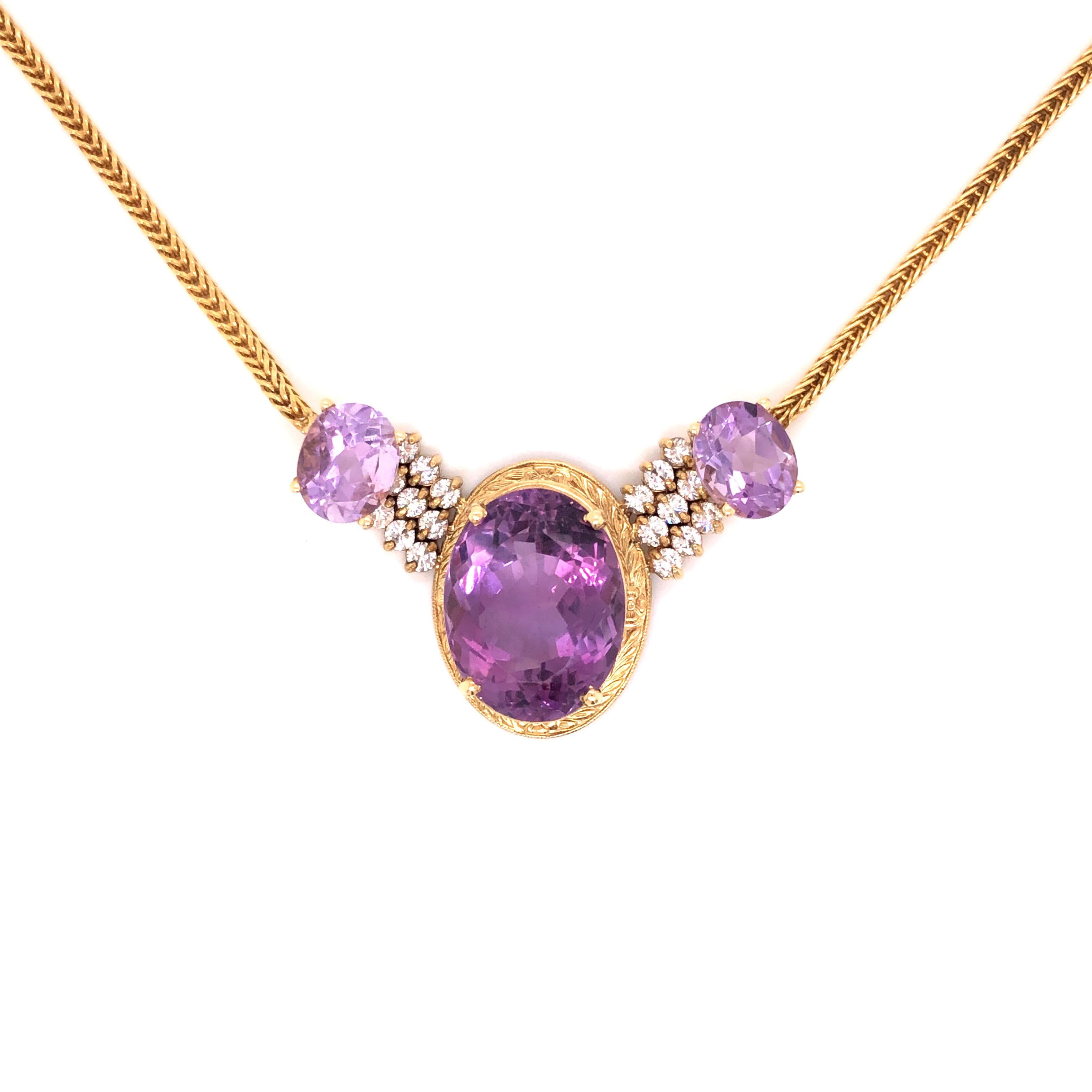 A vintage necklace featuring an 18K yellow gold 2.10mm wheat chain attached to a 14K yellow gold pendant containing 3 oval amethyst with the center amethyst measuring approximately 14.5mm x 18.80mm, enhanced by round-cut diamonds weighing a total of