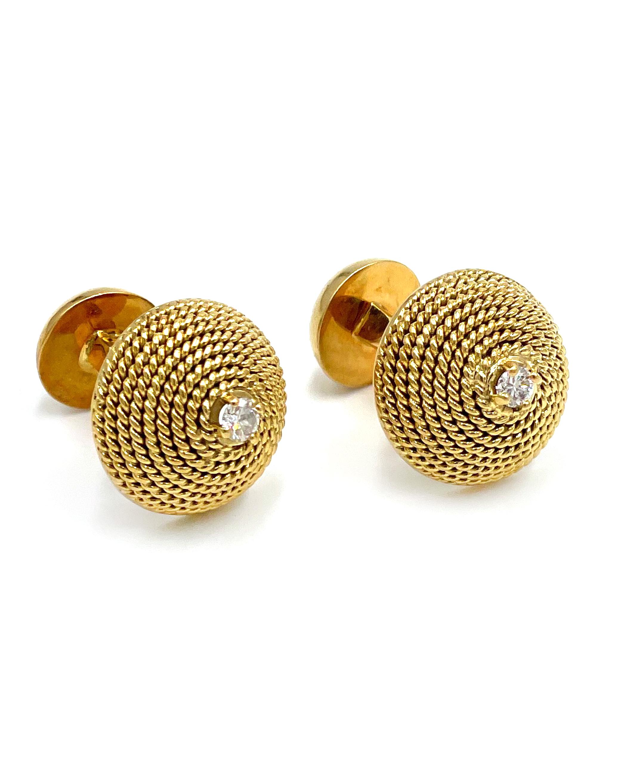 Preowned pair of 18K yellow gold and diamond cufflinks. The round links are a dome of twisted wire. Each
cufflink has one round brilliant-cut diamond; the total carat weight of both diamonds together is
approximately 0.30 carats.

* The diamonds are