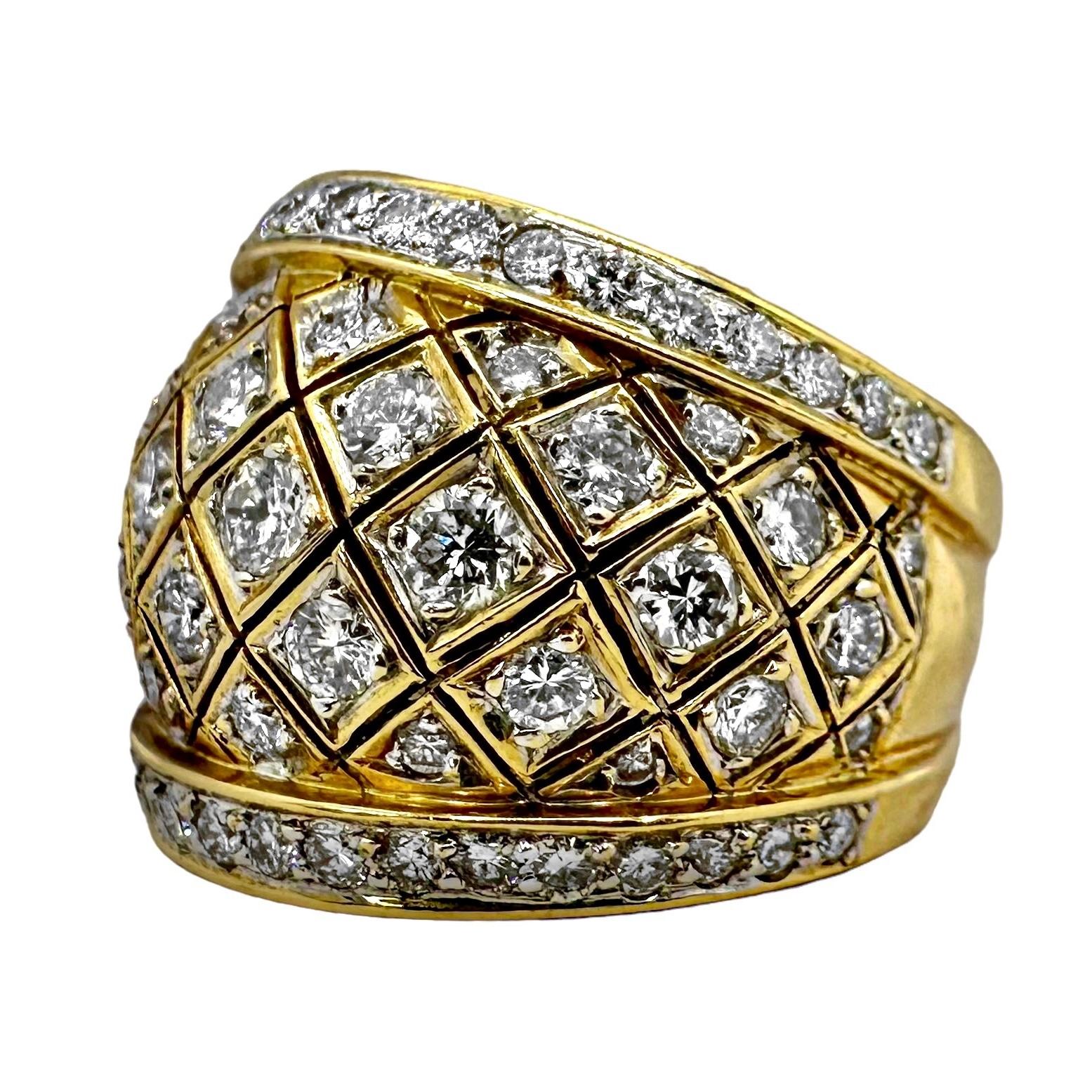 Un anello a bombe, con lavorazione a reticolo, intricato e dettagliato, realizzato in oro giallo 18 carati con diamanti incastonati nell'area frontale del disegno e in un'unica linea nella parte superiore e inferiore. I diamanti rotondi assortiti