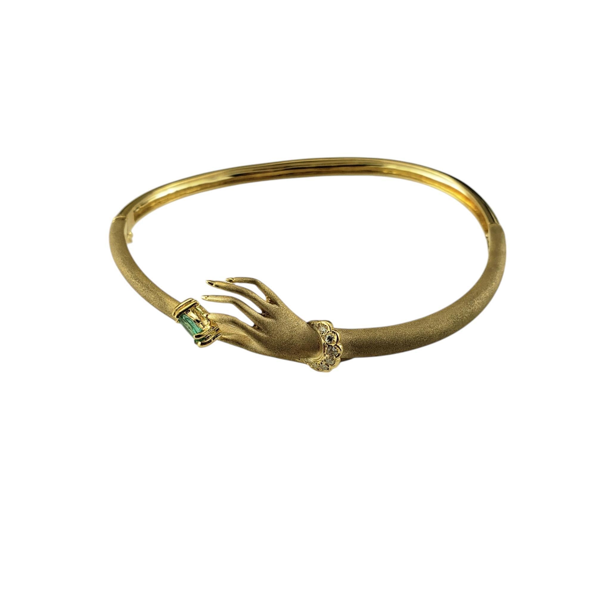 Bracelet en or jaune 18K et diamants avec émeraude à la main-

Ce charmant bracelet à charnière présente une main gracieuse tenant une émeraude de taille marquise (6 mm x 4 mm) sertie dans de l'or jaune 18 carats magnifiquement détaillé. Le poignet