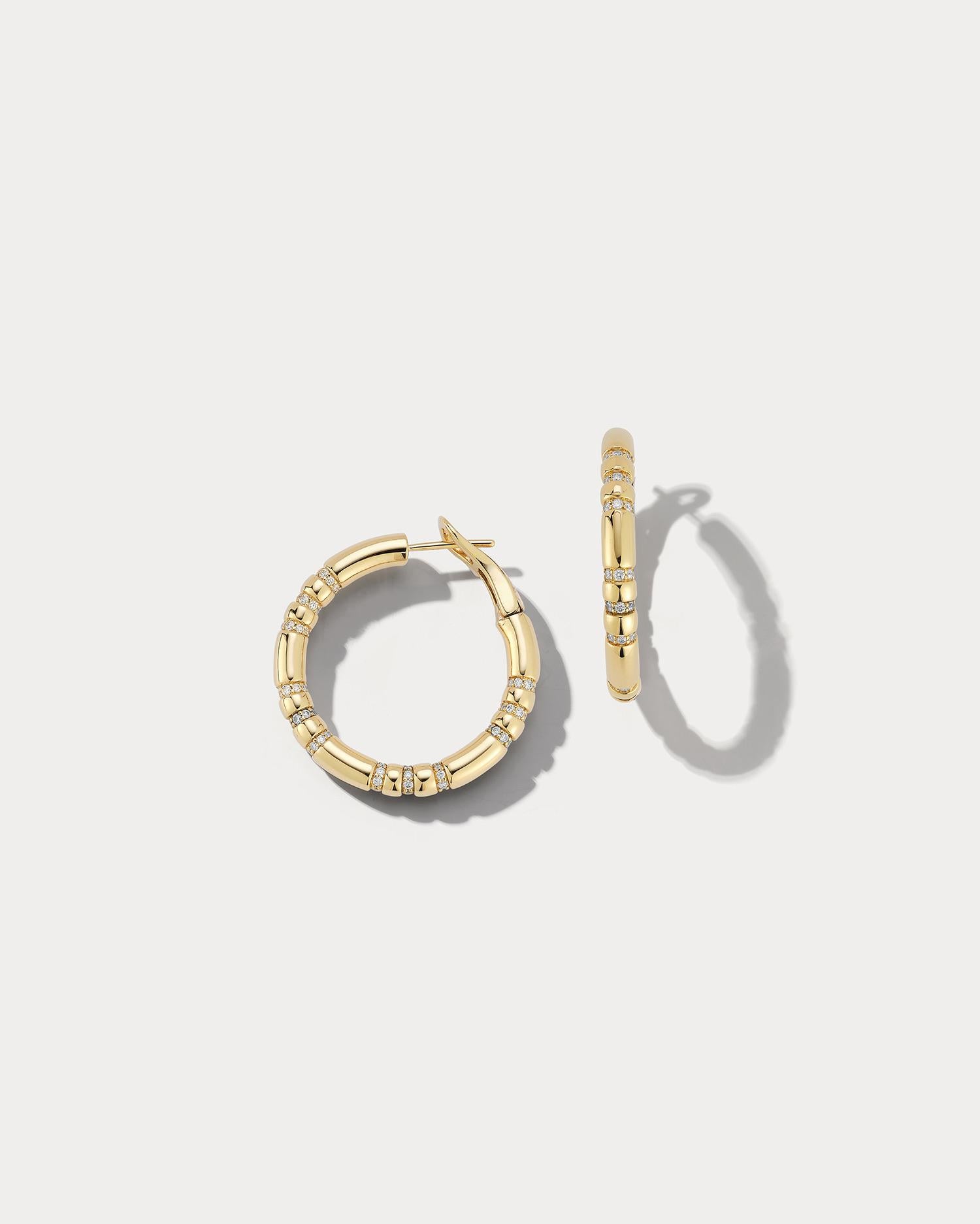 These charming hoop earrings are crafted from 18k yellow gold and feature accents of 1.56 carats of dazzling diamonds. The hoops are small in size, making them perfect for everyday wear or to add a touch of glamour to a special occasion. The